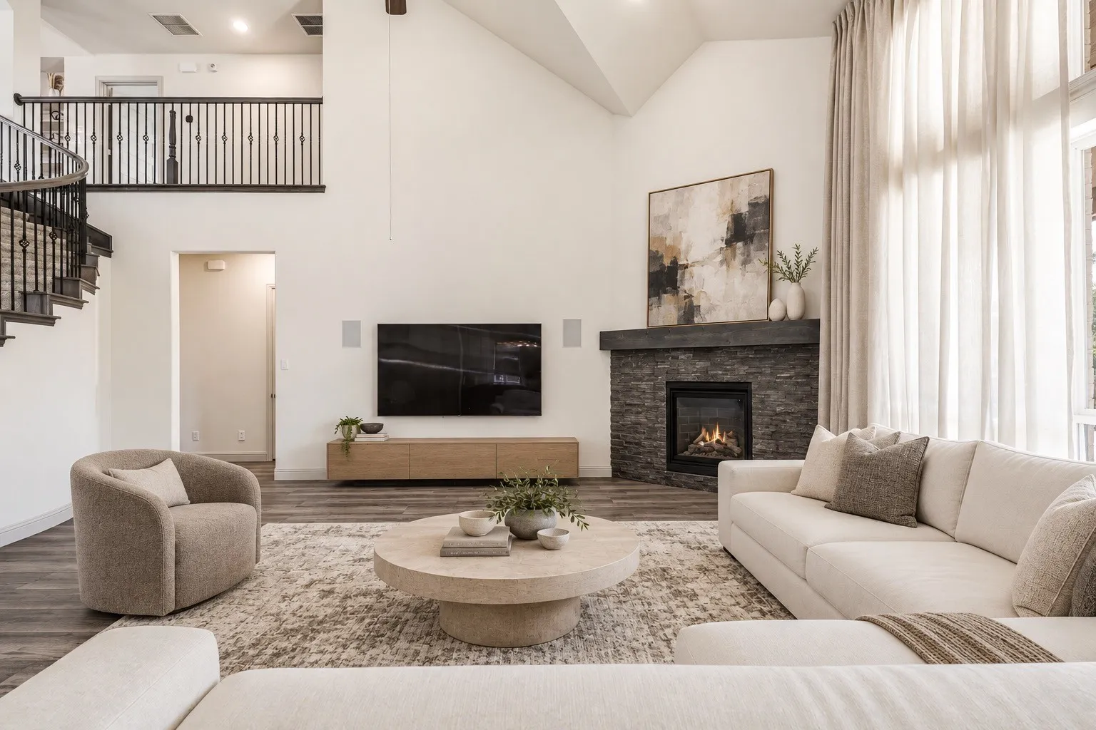 Vaulted ceiling with exposed beam, stone-clad fireplace, wood-finish flooring, and spiral staircase with dark wood and wrought iron balusters --staging with AI
