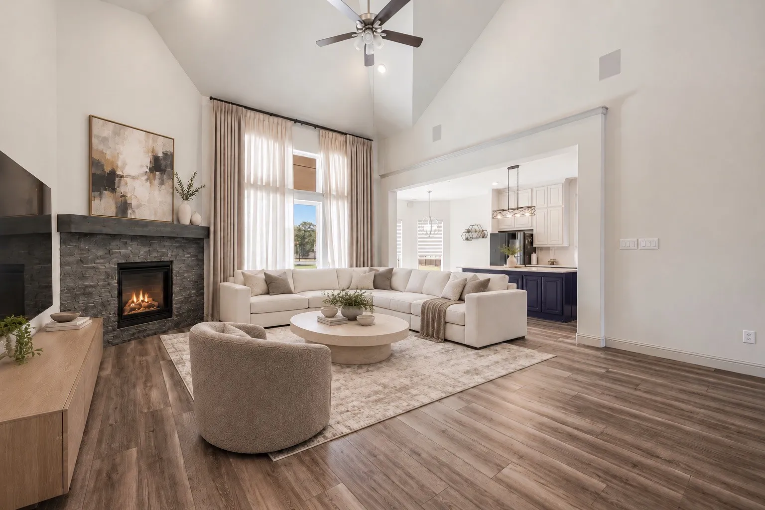 Vaulted ceiling with a ceiling fan, stone-clad fireplace with mantel, wood-finish flooring, and large windows -staging with AI