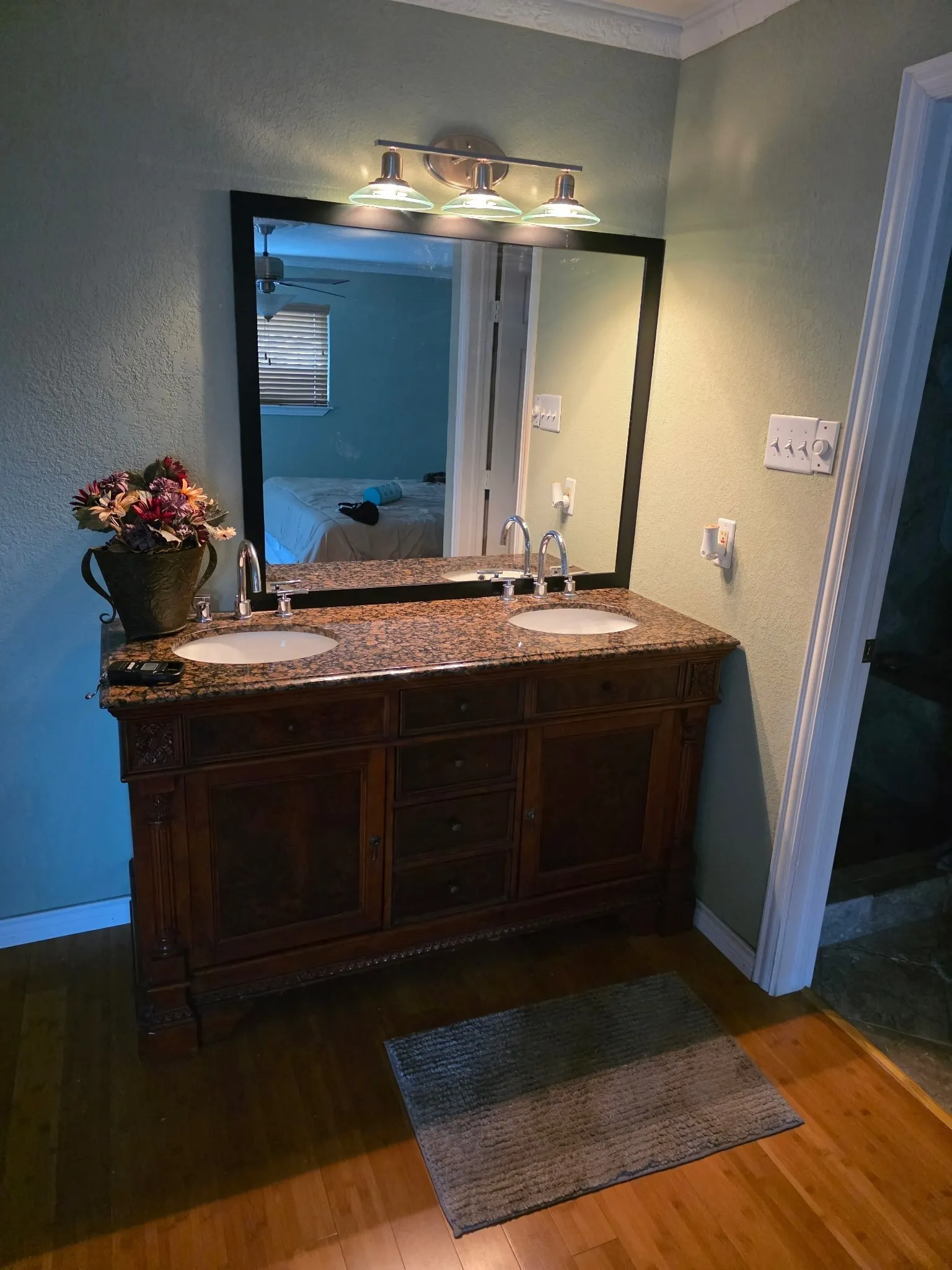 Bathroom featuring double vanity, ensuite bath, wood finished floors, and a sink