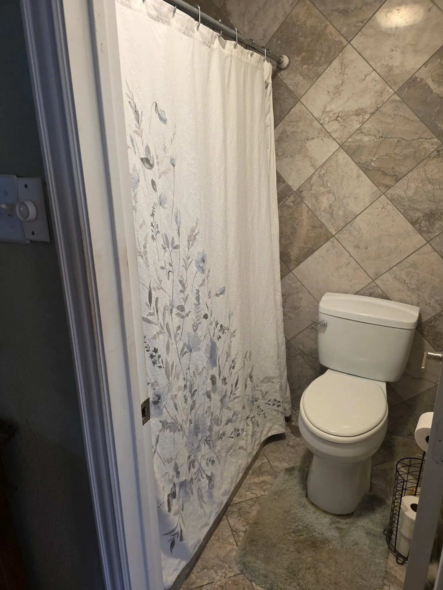 Full bathroom featuring toilet and a shower with curtain