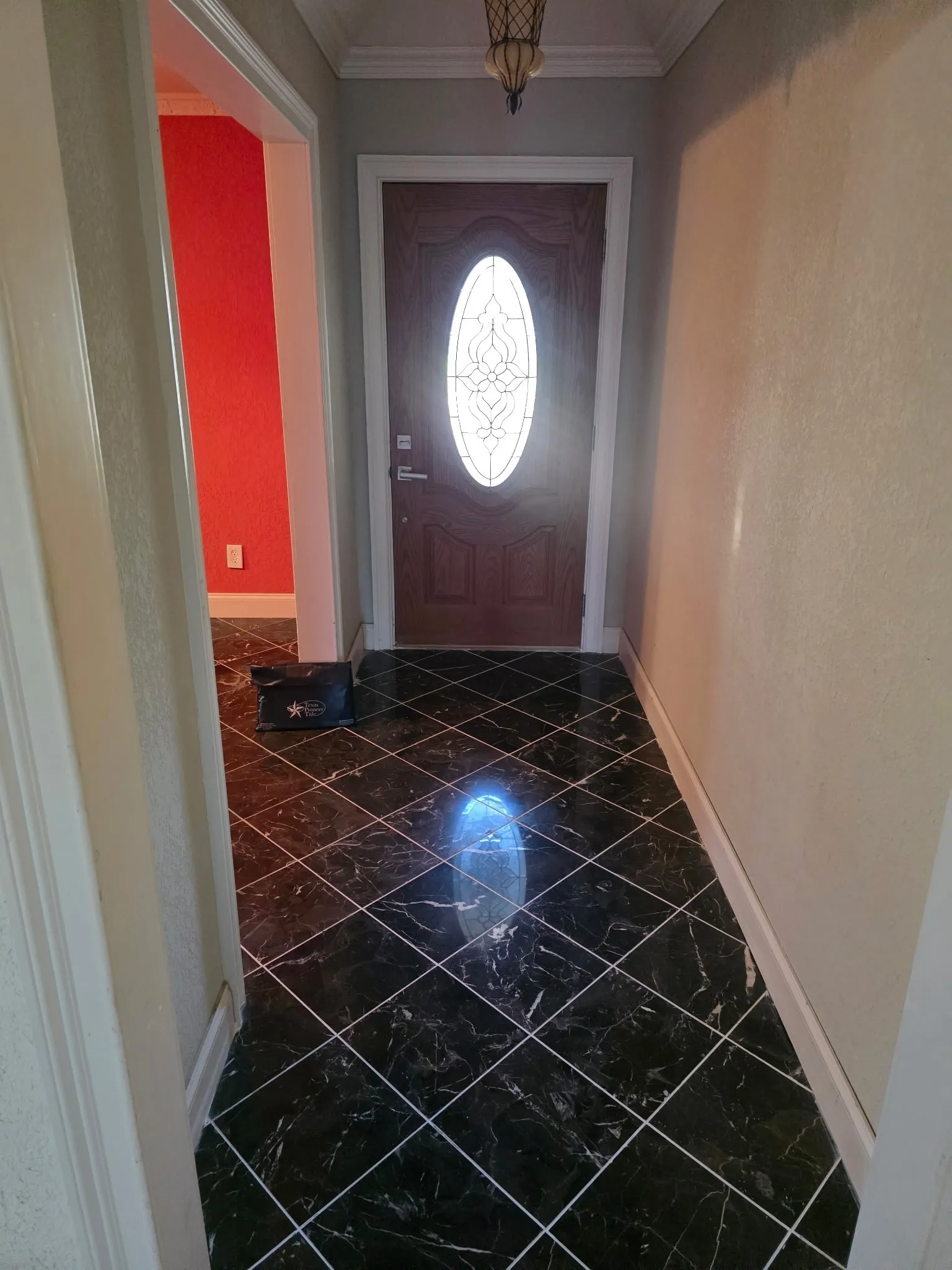 Entrance foyer featuring crown molding, baseboards, and marble finish floor