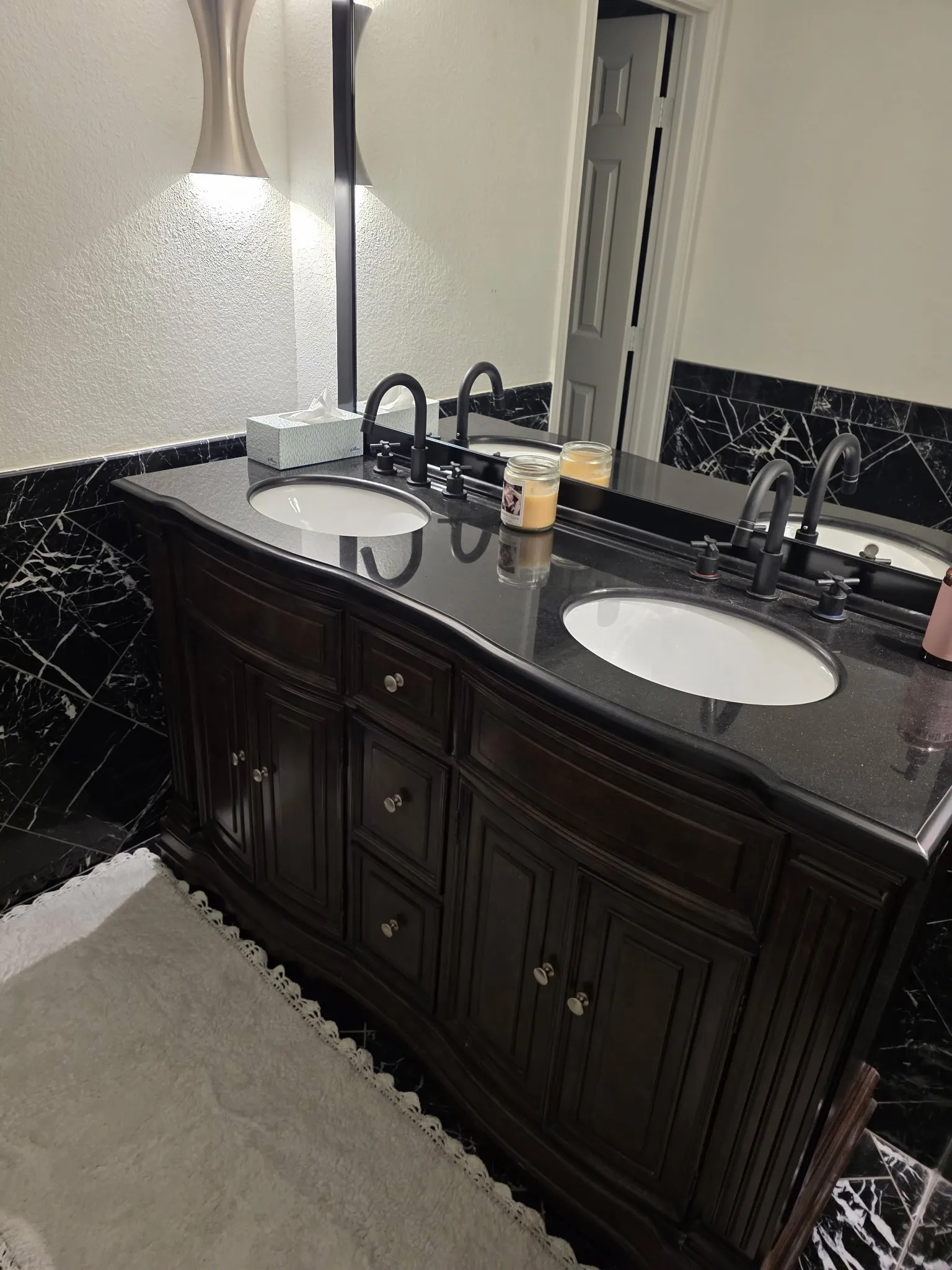 Full bathroom with marble finish floor, double vanity, a sink, and a textured wall