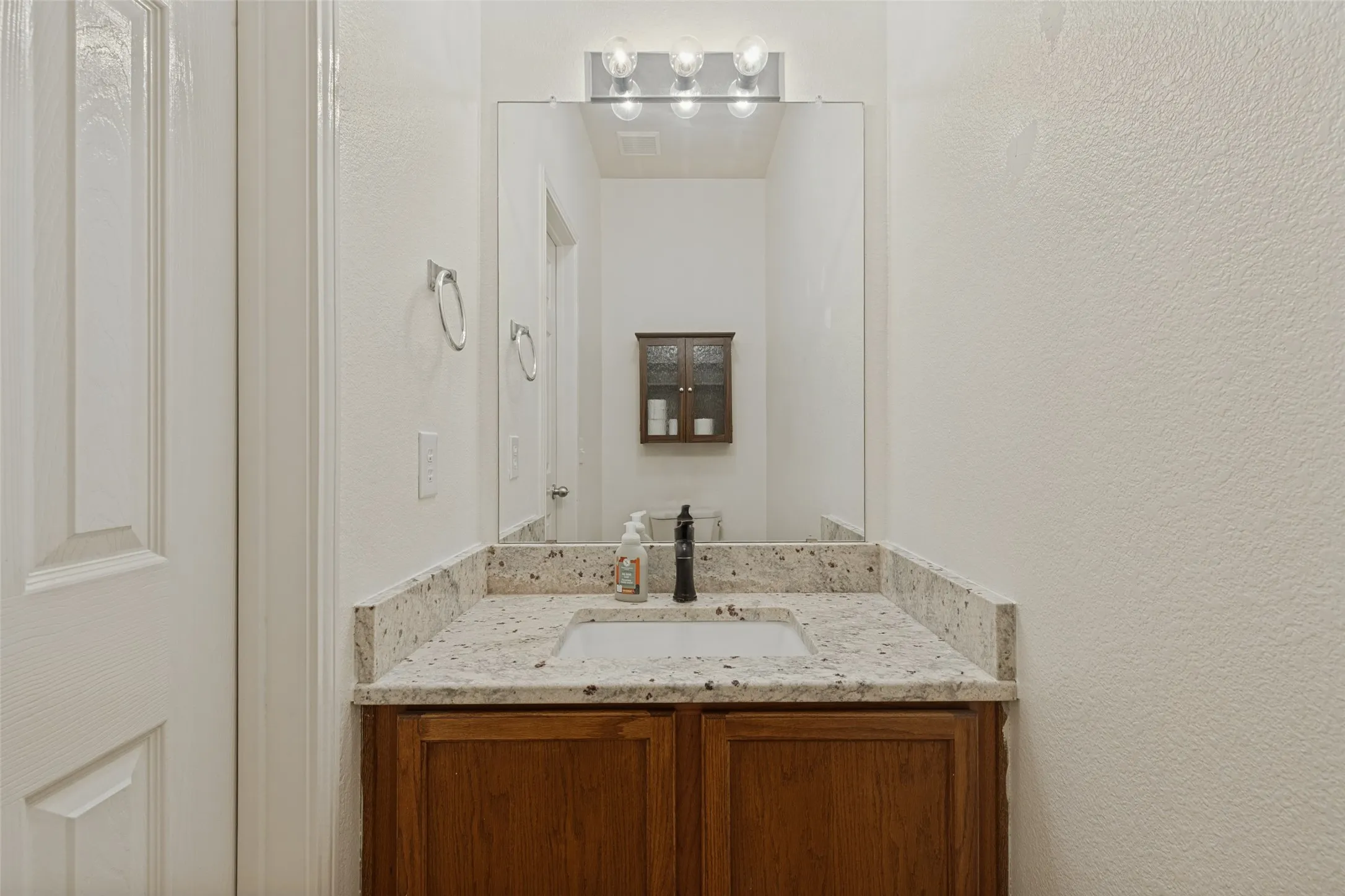Granite Countertop and Additional Cabinet Over Toilet