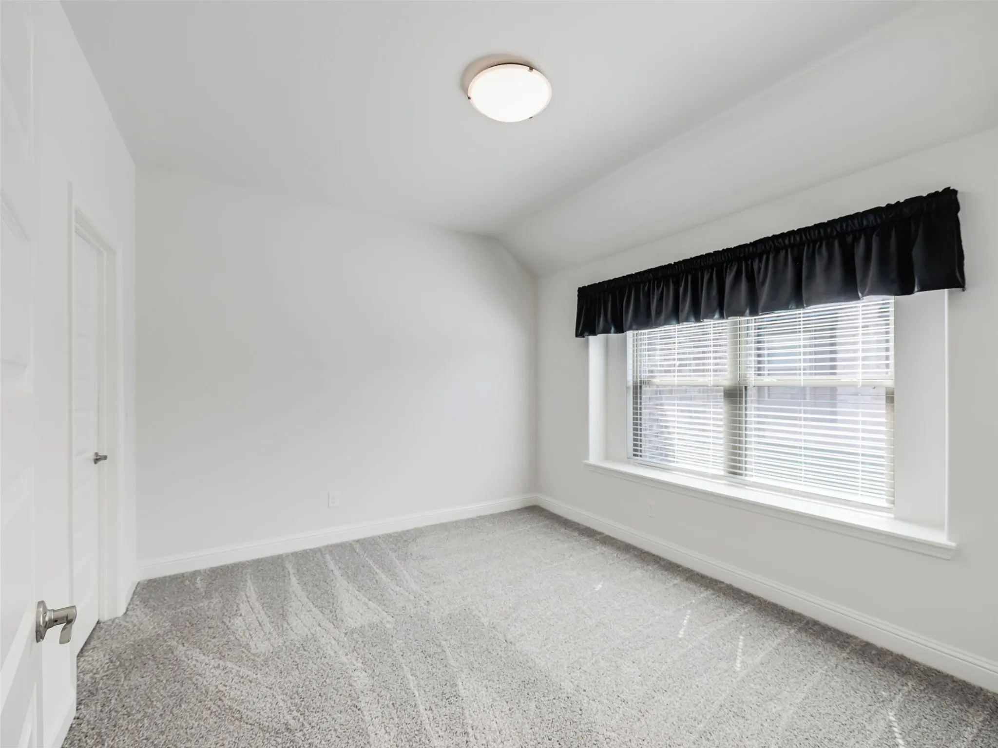 Neutral wall finishes with a ceiling-mounted light fixture