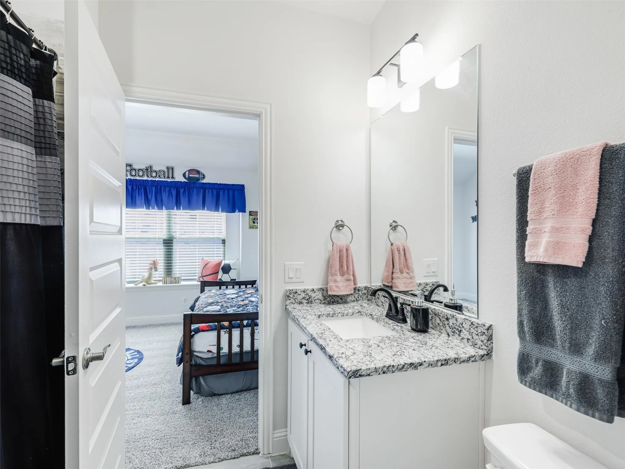 White vanity with a speckled countertop and integrated sink