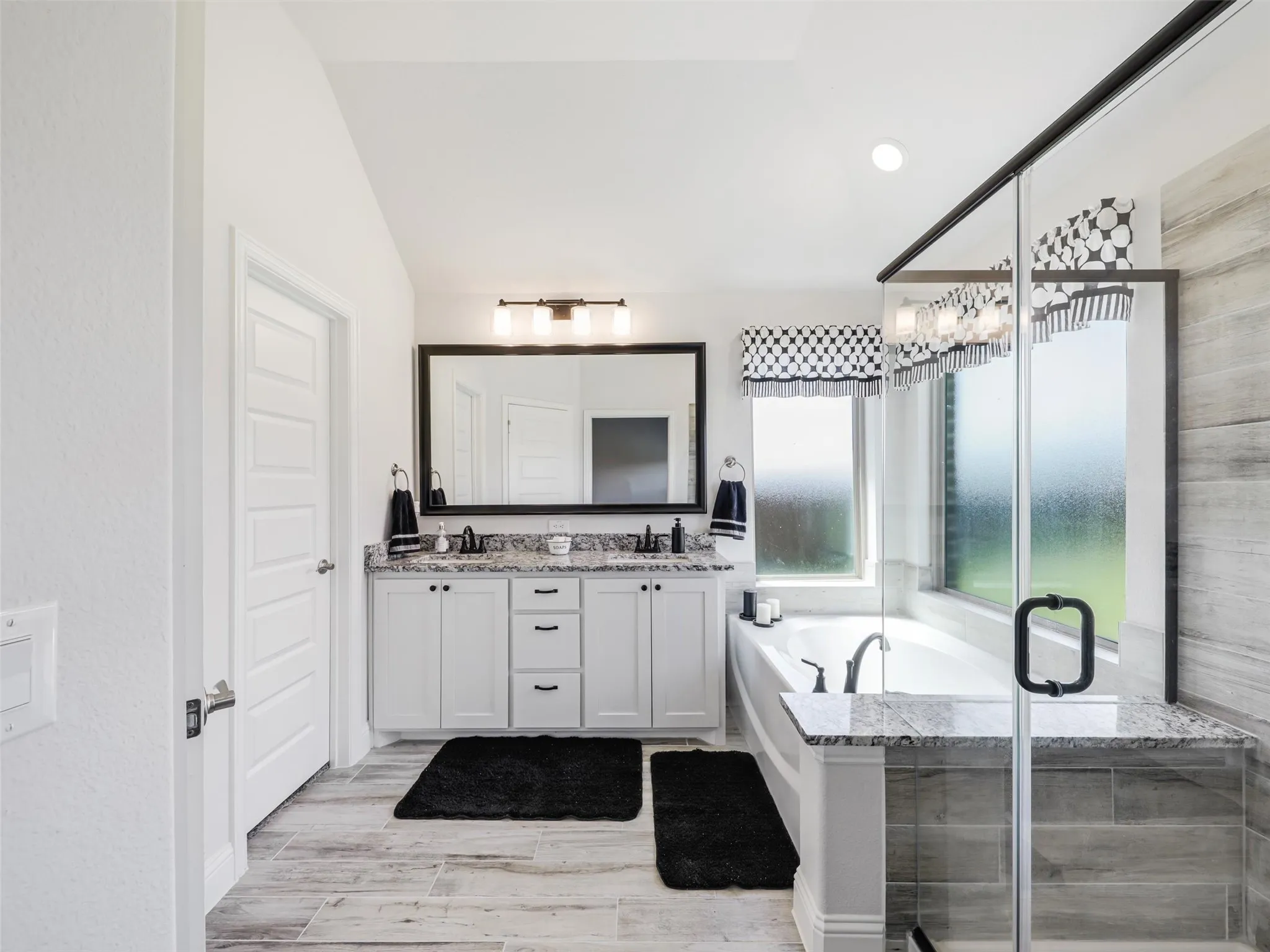 White shaker cabinetry, dark wood-finish flooring, recessed lighting, double kitchen islands, and stainless steel appliances