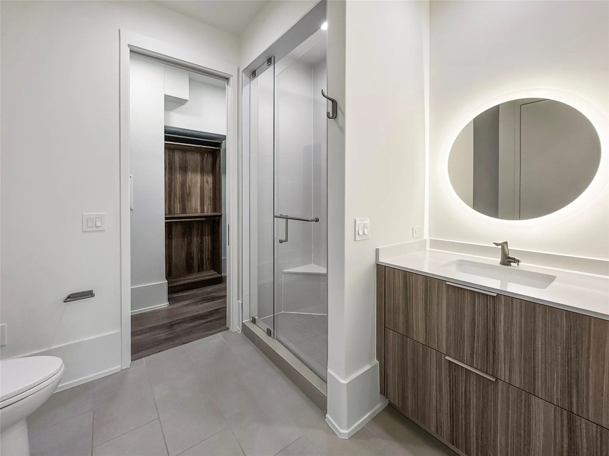 Bathroom featuring walk in shower, tile patterned floors, toilet, and vanity