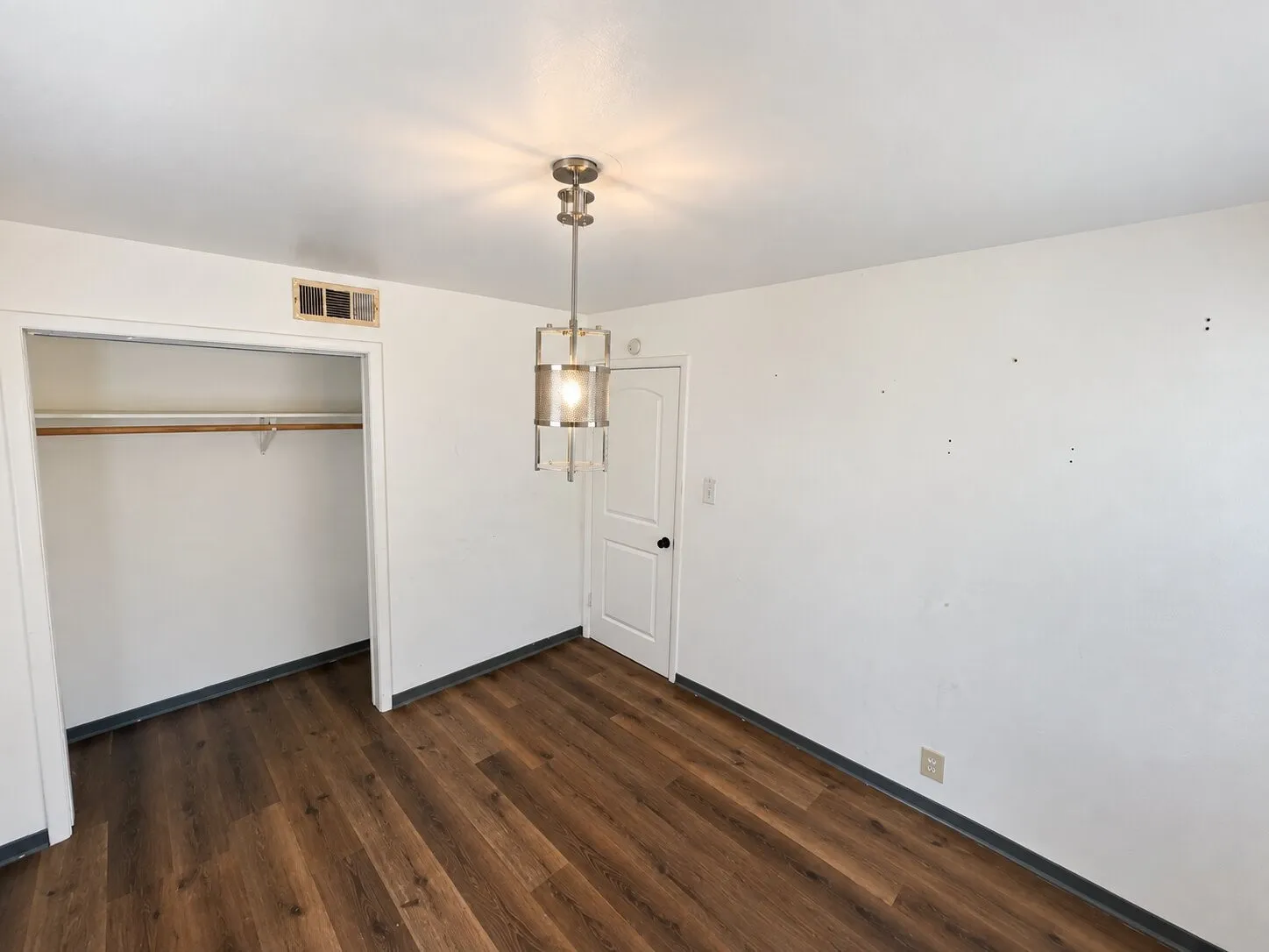Virtually staged -
Wood-finish flooring, recessed closet with shelving, ceiling-mounted light fixture, white interior door with black hardware