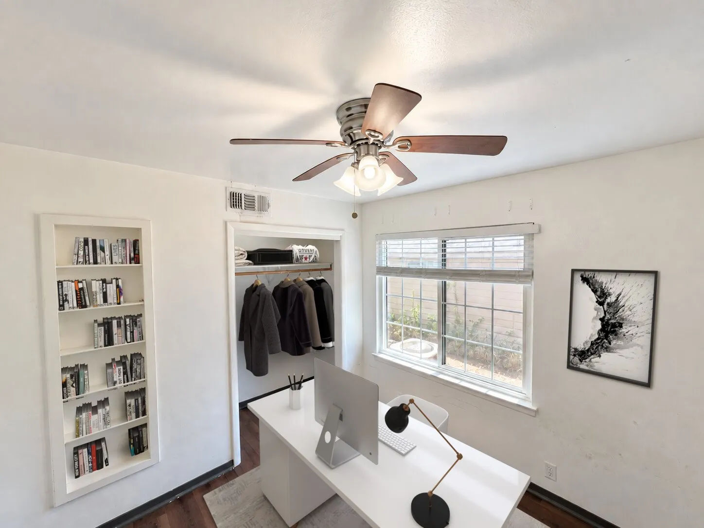 Virtually staged -
Built-in shelving, a closet with a hanging rod, a window with blinds, wood-finish flooring, and a ceiling fan with integrated lighting