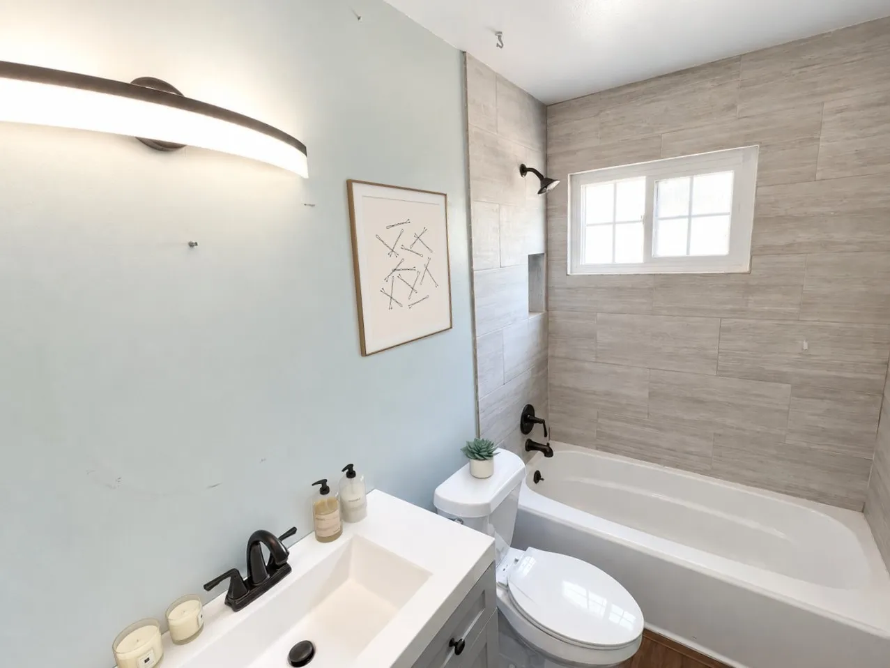 Virtually staged -
Modern vanity with integrated sink, matte black faucet, and contemporary light fixture