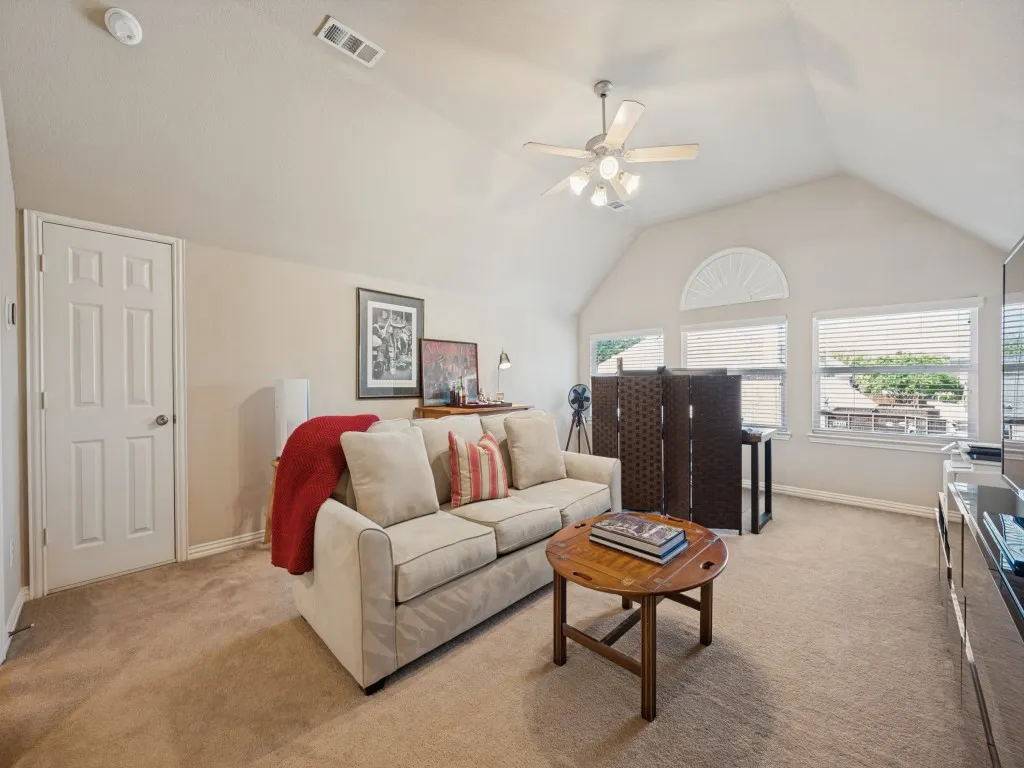 The spacious upstairs game room is currently styled as a comfortable TV room, offering a versatile space for movie nights, game days, entertaining, or relaxing with family and friends.