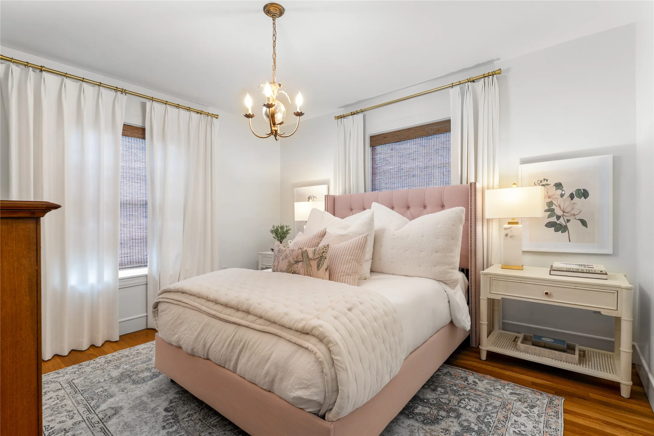 Hardwood flooring, chandelier lighting, and a window with blinds