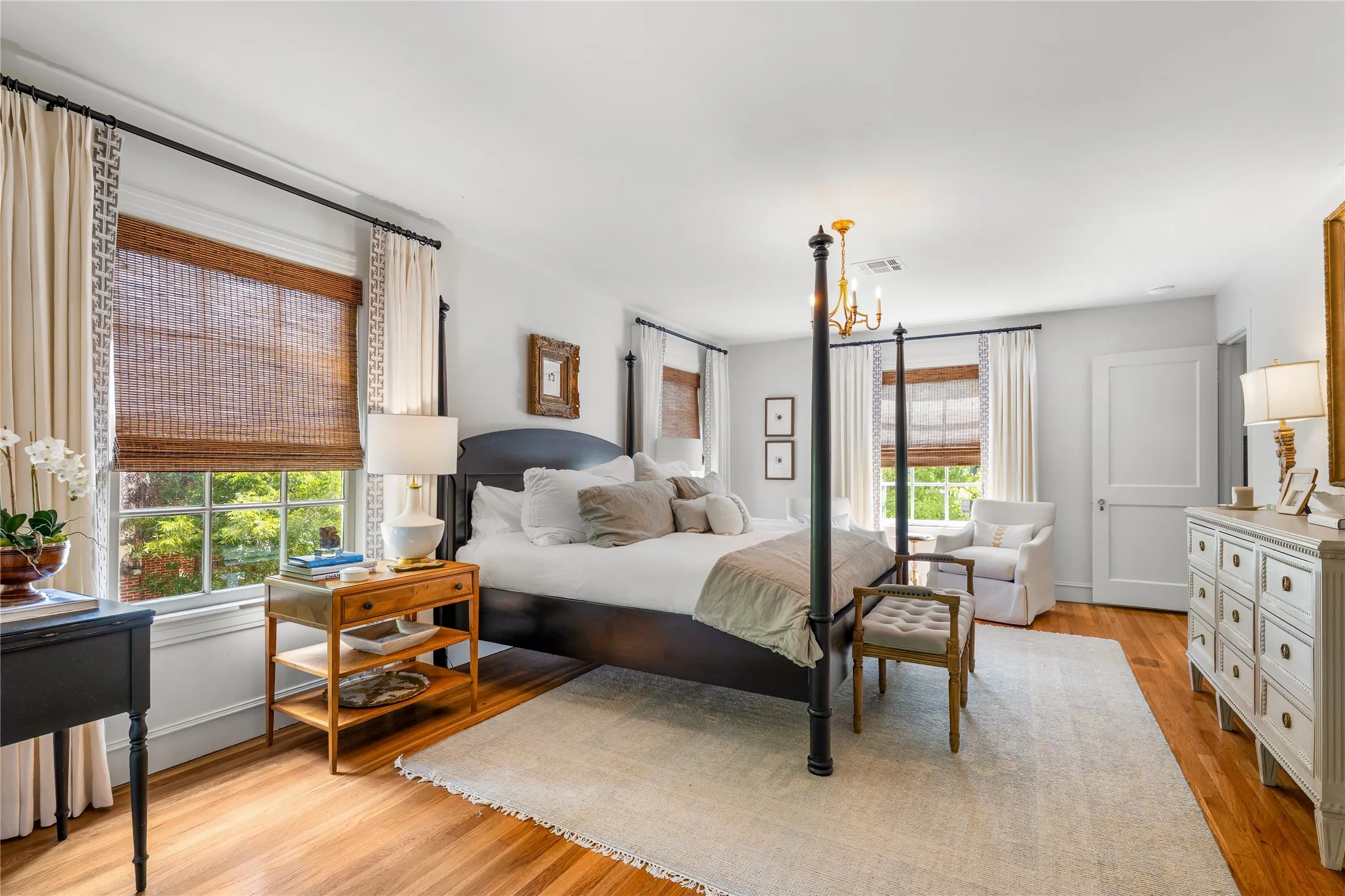 Hardwood flooring, multiple windows with blinds and drapes, recessed lighting, and a solid core interior door