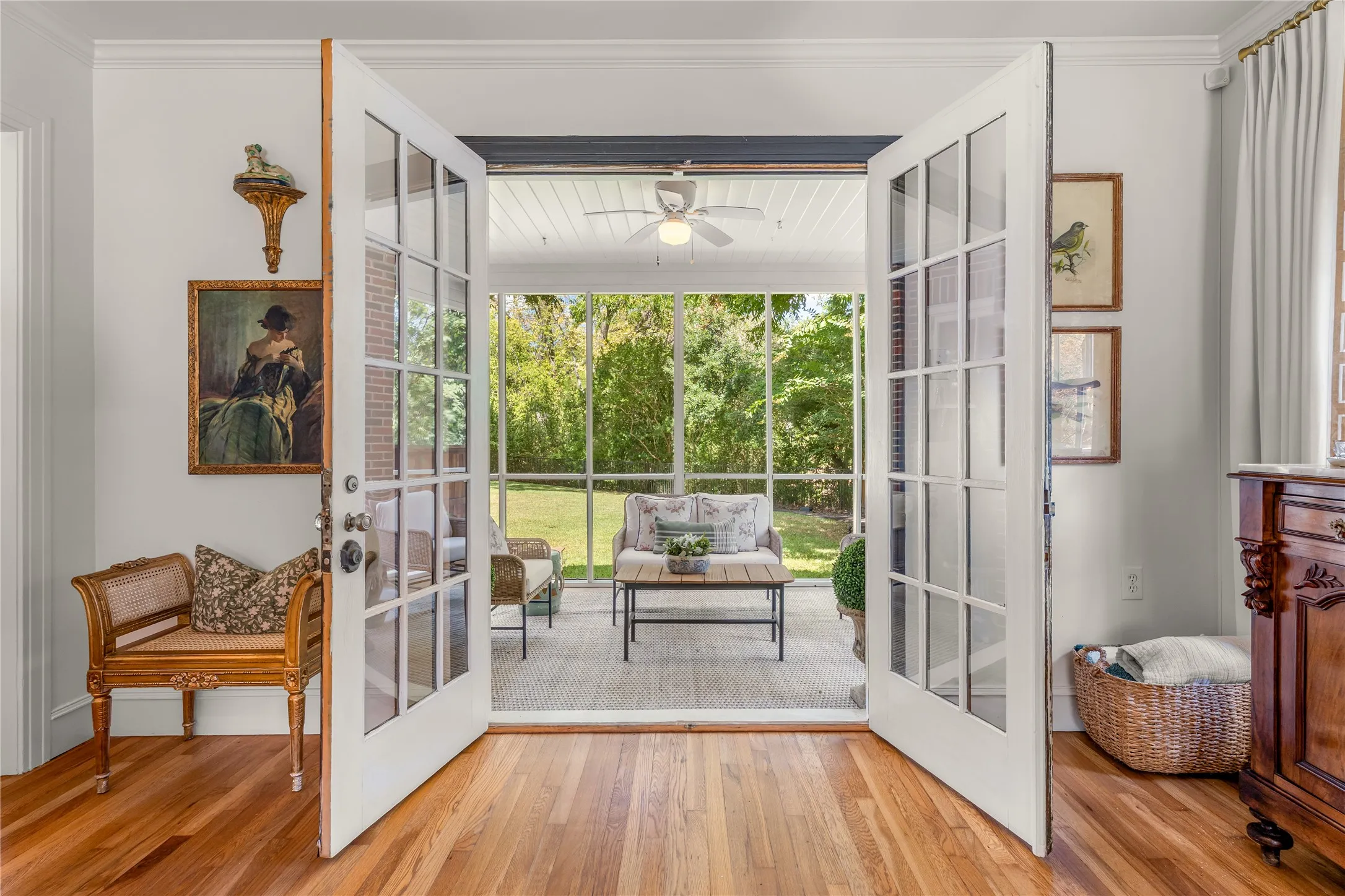 Hardwood flooring, white French doors, screened porch, ceiling fan, and crown molding