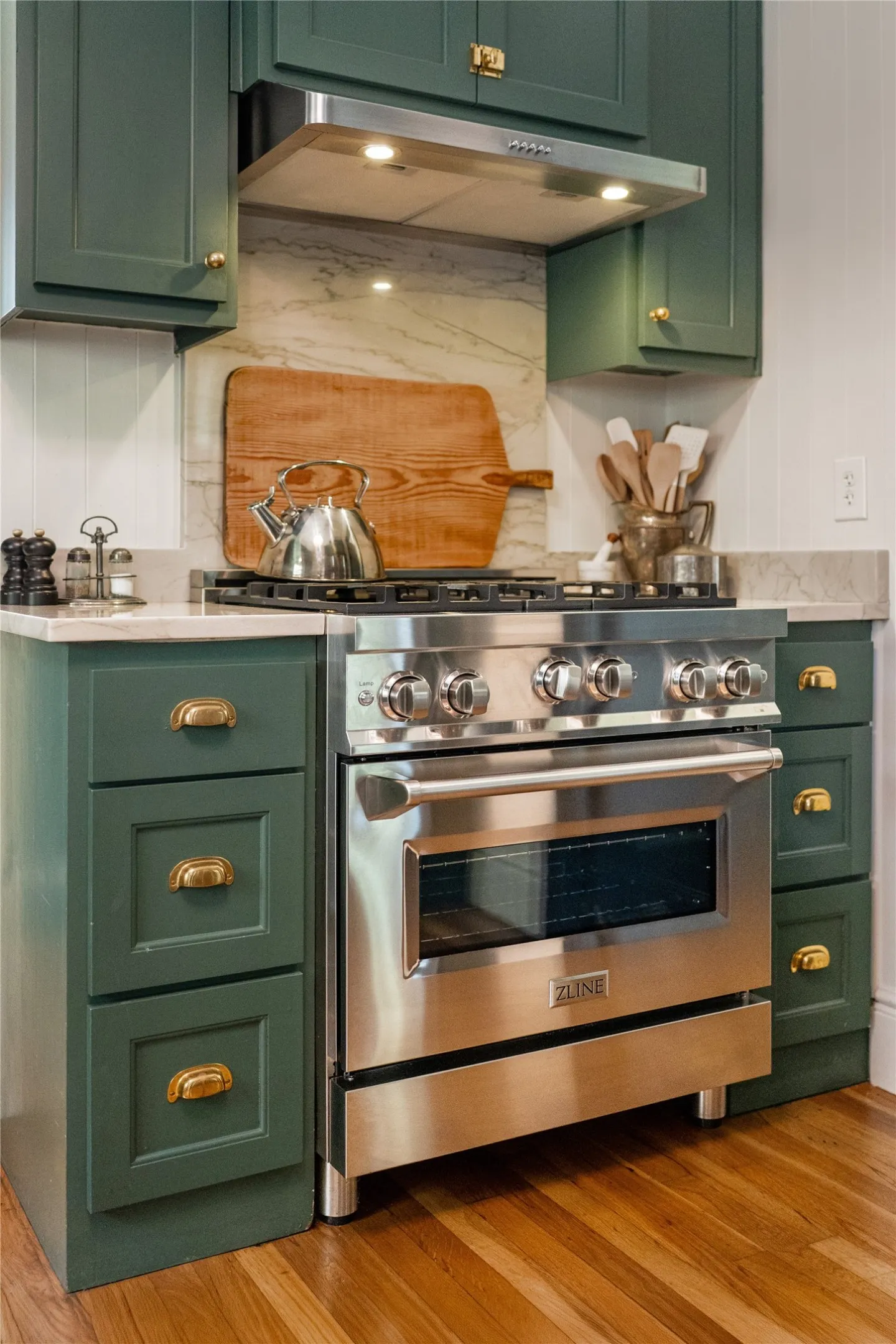 Stainless steel professional range, range hood, and marble-finish backsplash