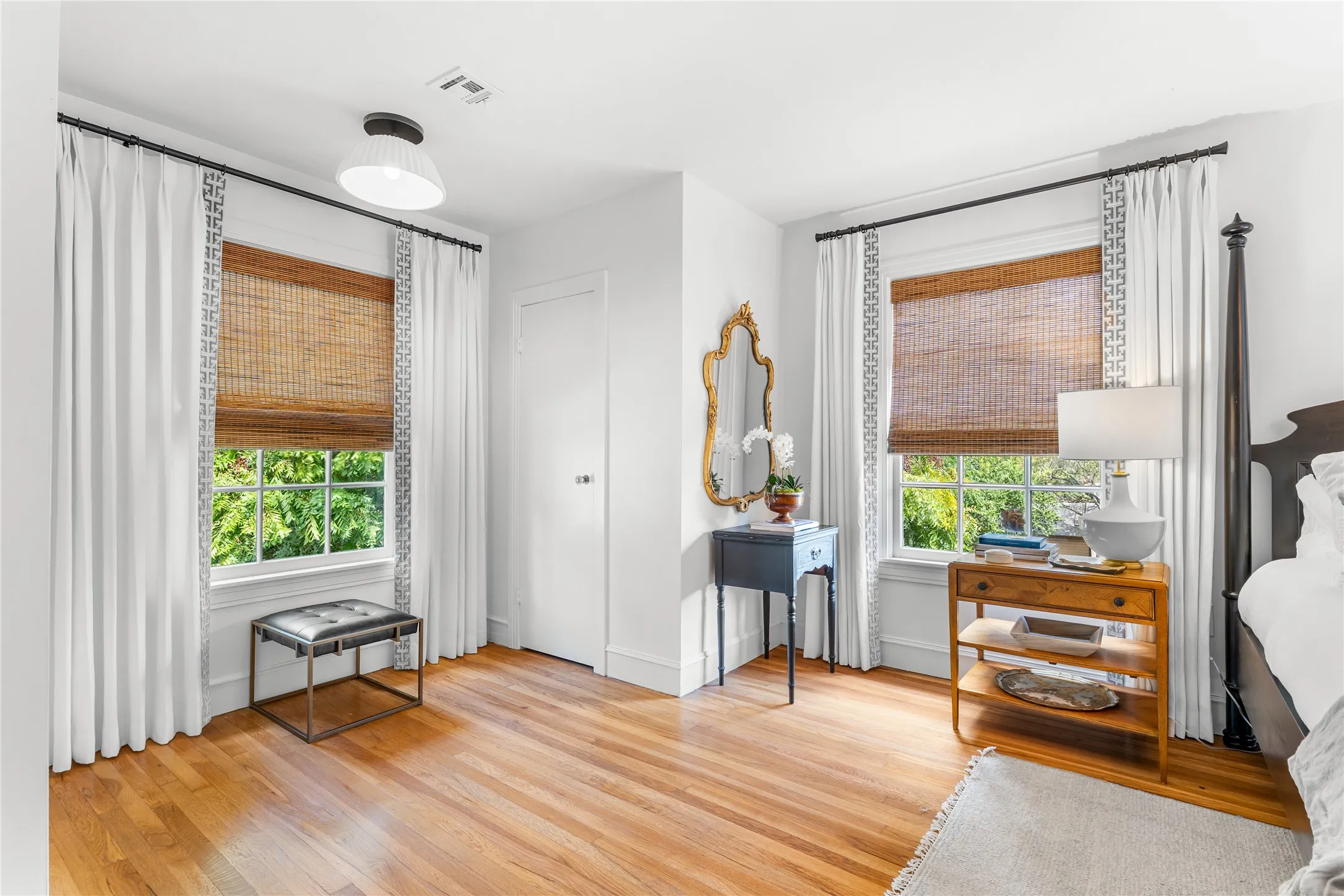 Wood-finish flooring, white walls, and a contemporary flush-mount light fixture