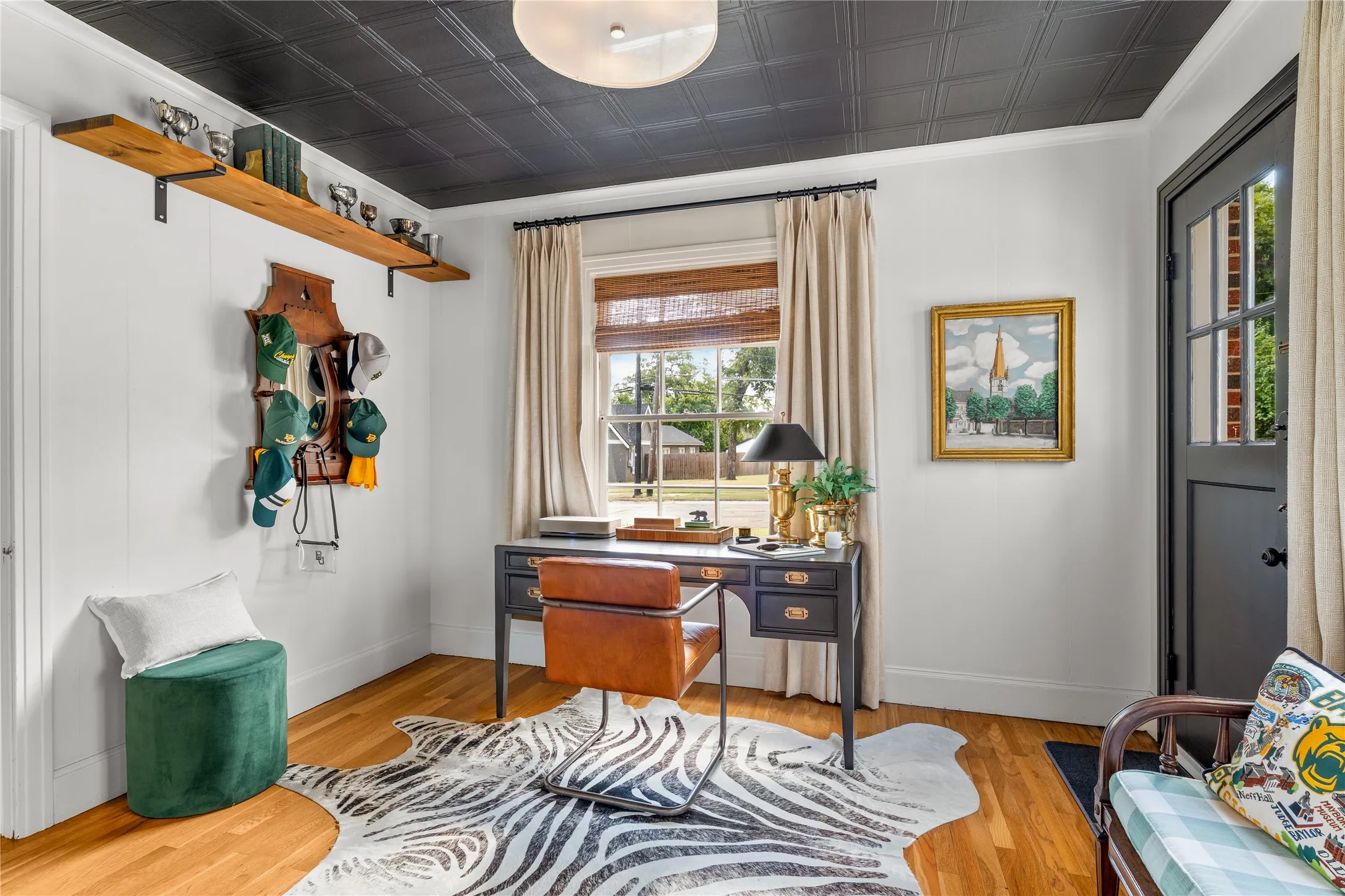 Wood-finish flooring, white paneled walls, and a black coffered ceiling