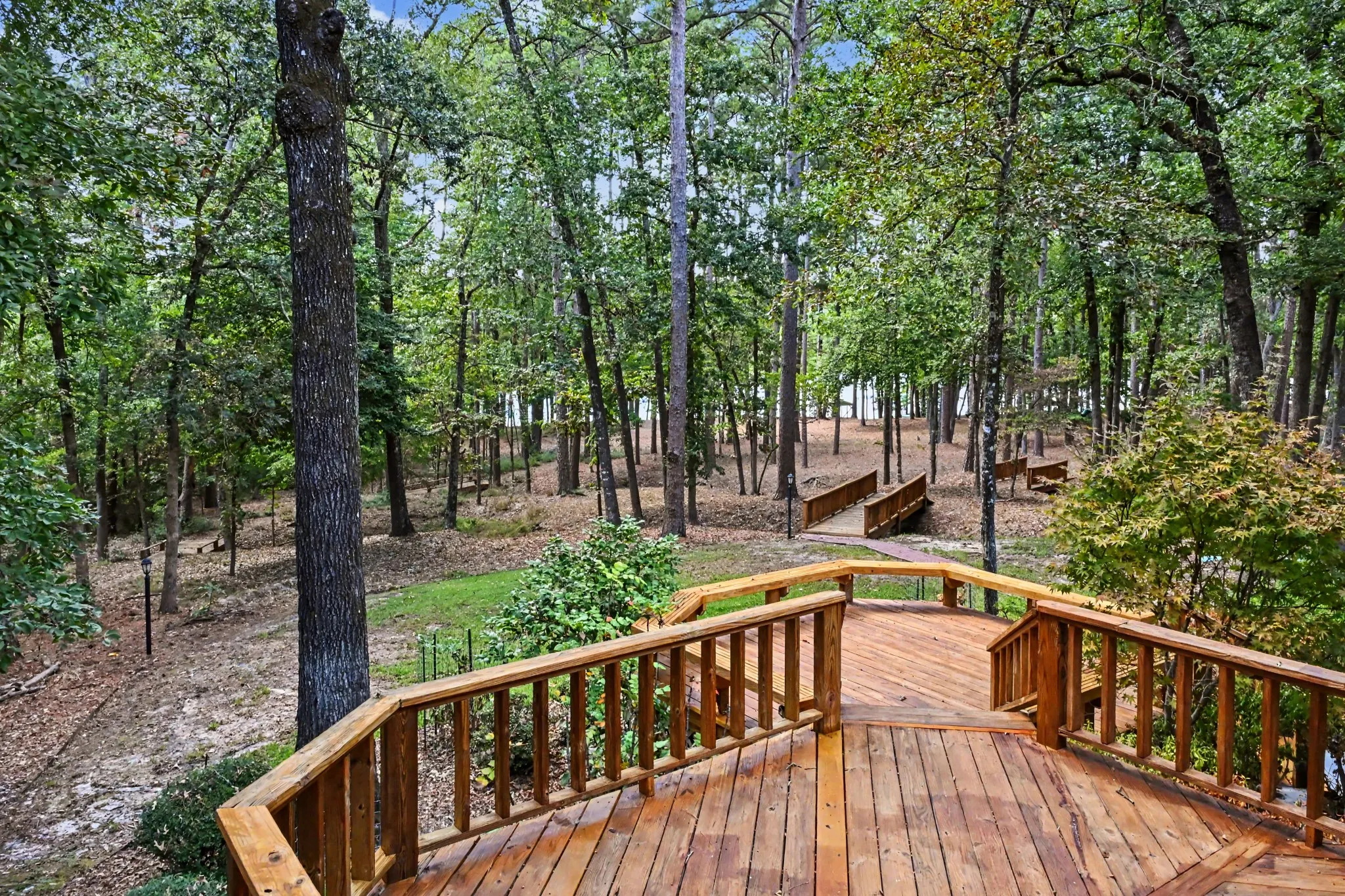 Tiered deck overlooking wooded lot and lake