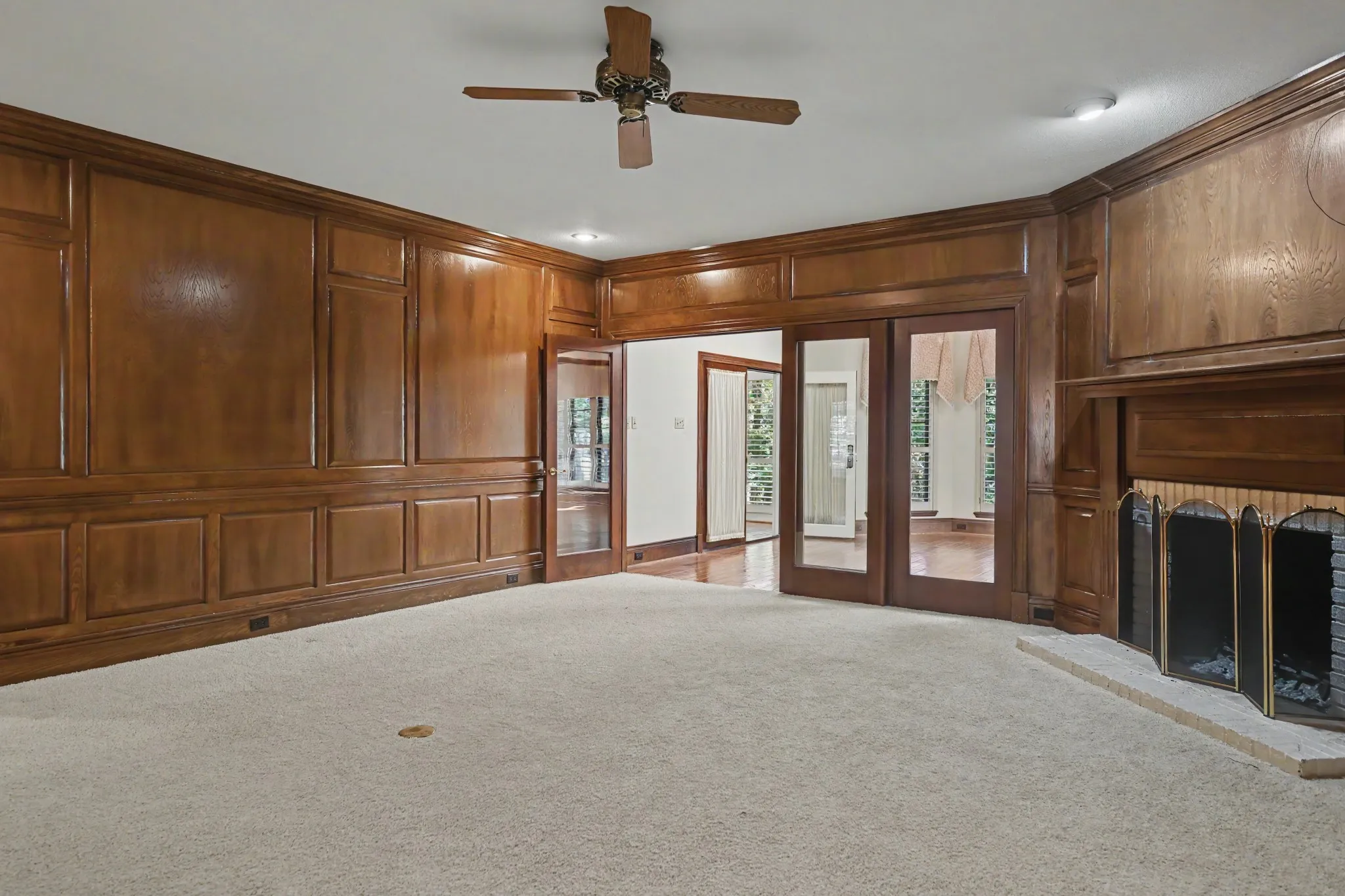 Glass doors and windows create a view into back family room and outdoors