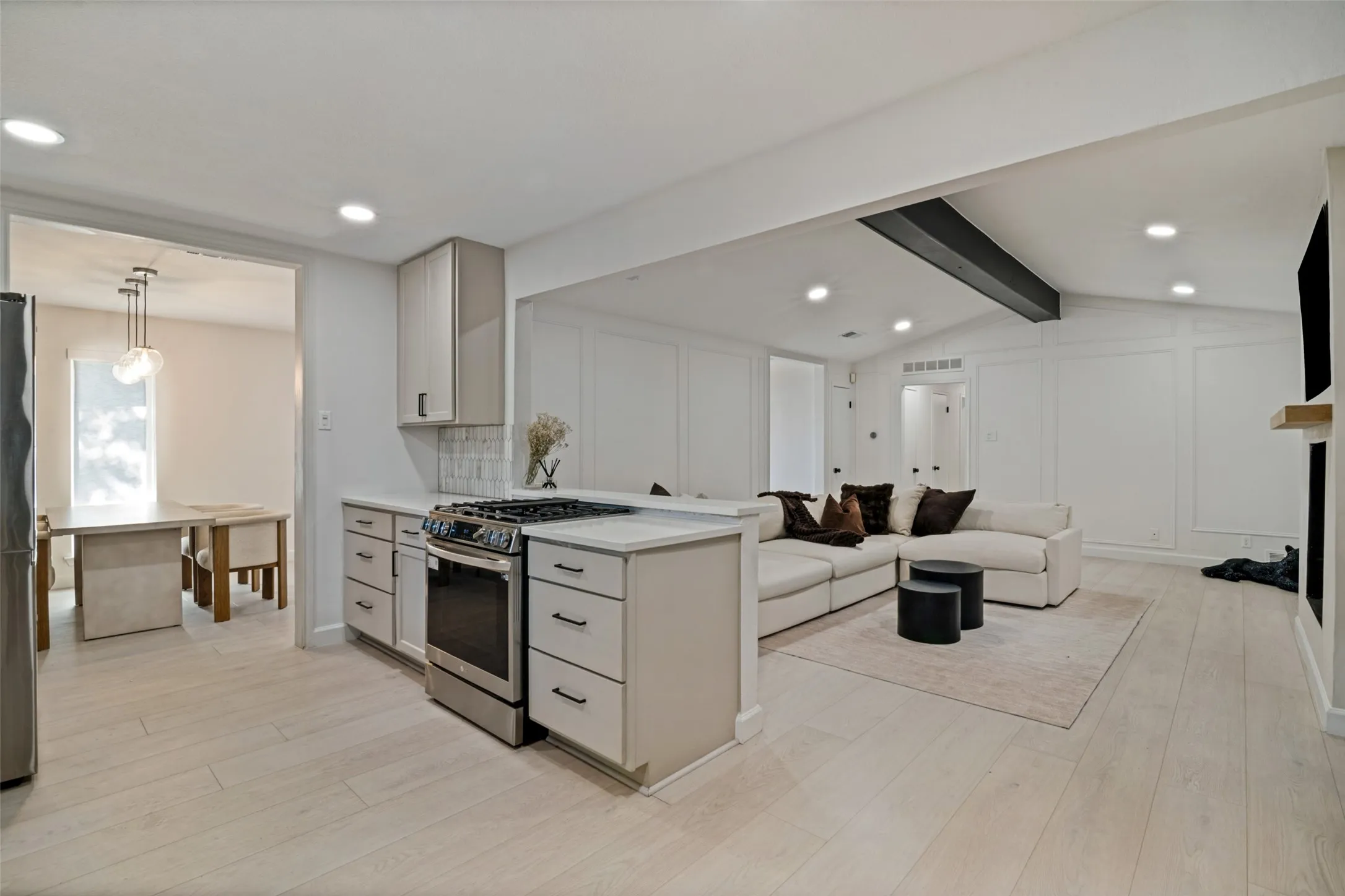 Kitchen with light-toned cabinetry and stainless-steel range