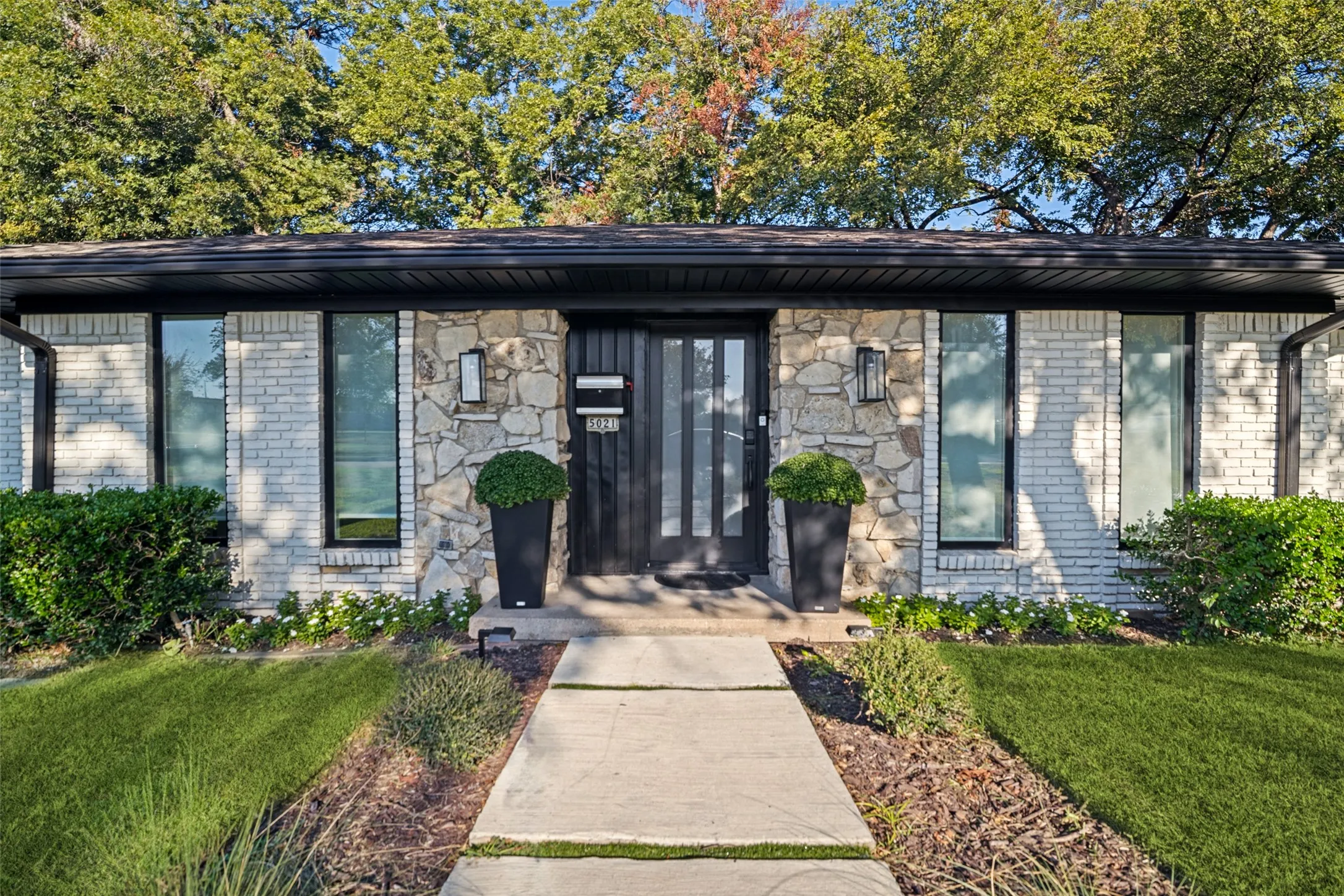 Stone and brick exterior with a black trim roofline