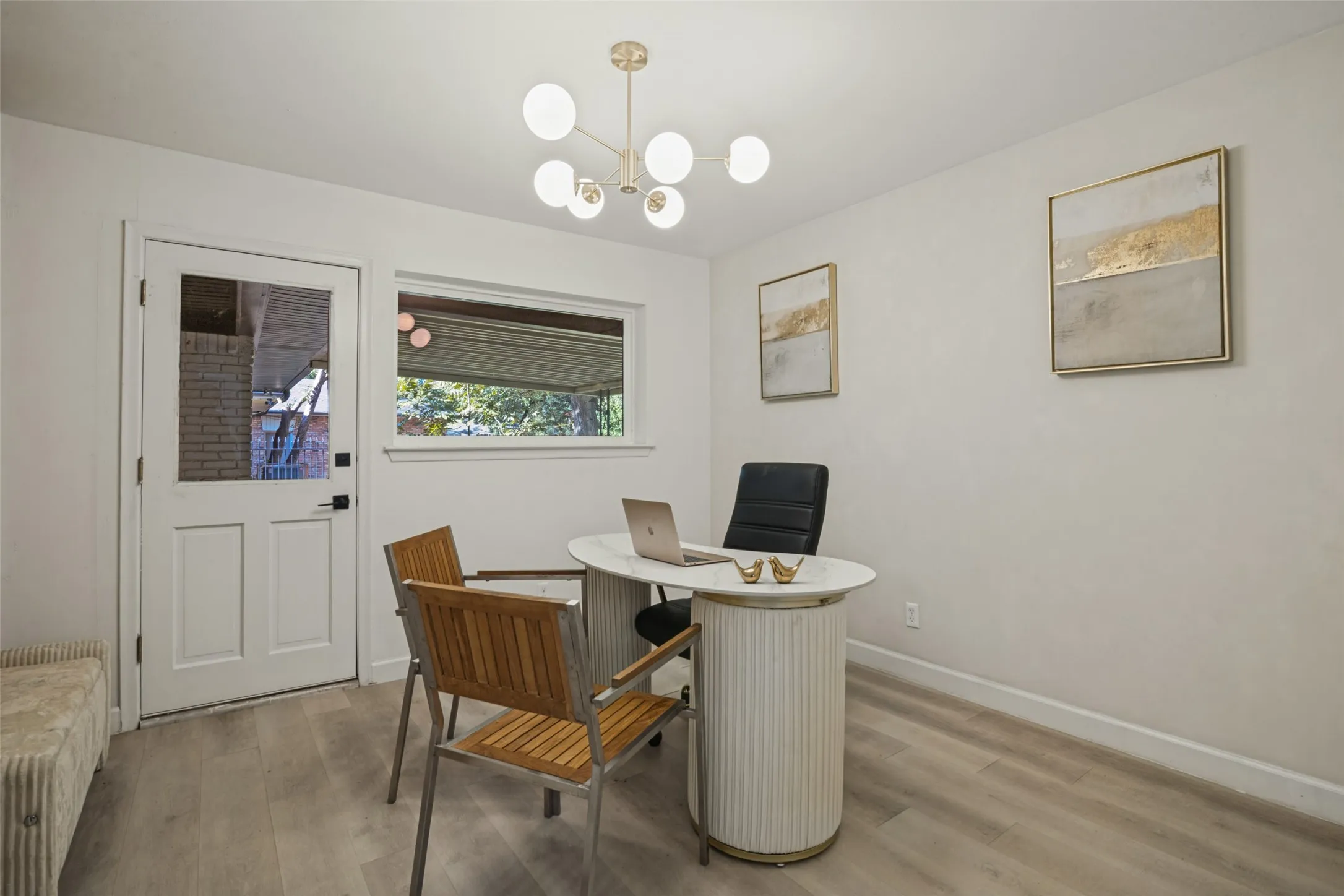 Neutral wall finishes, wood-finish flooring, a contemporary chandelier, a built-in window, and a door with an integrated window dimmer lights
