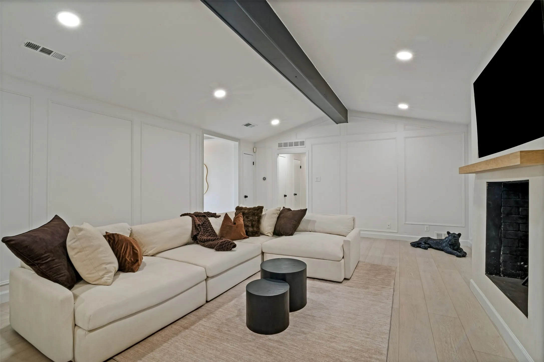 Living area featuring light wood-finish flooring, recessed lighting, and a fireplace with a light wood mantel