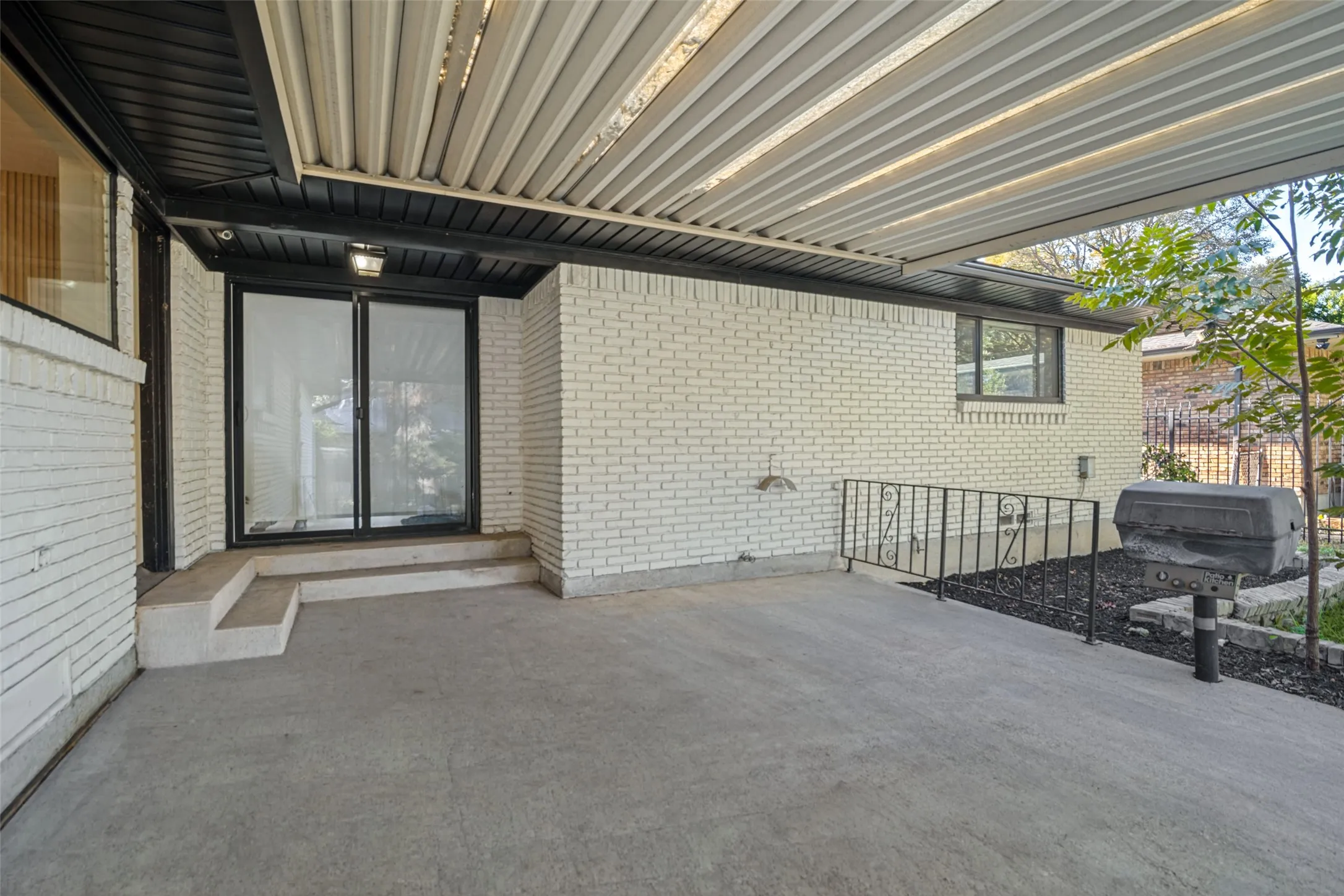 Patio featuring a covered area, concrete flooring, and sliding glass doors
