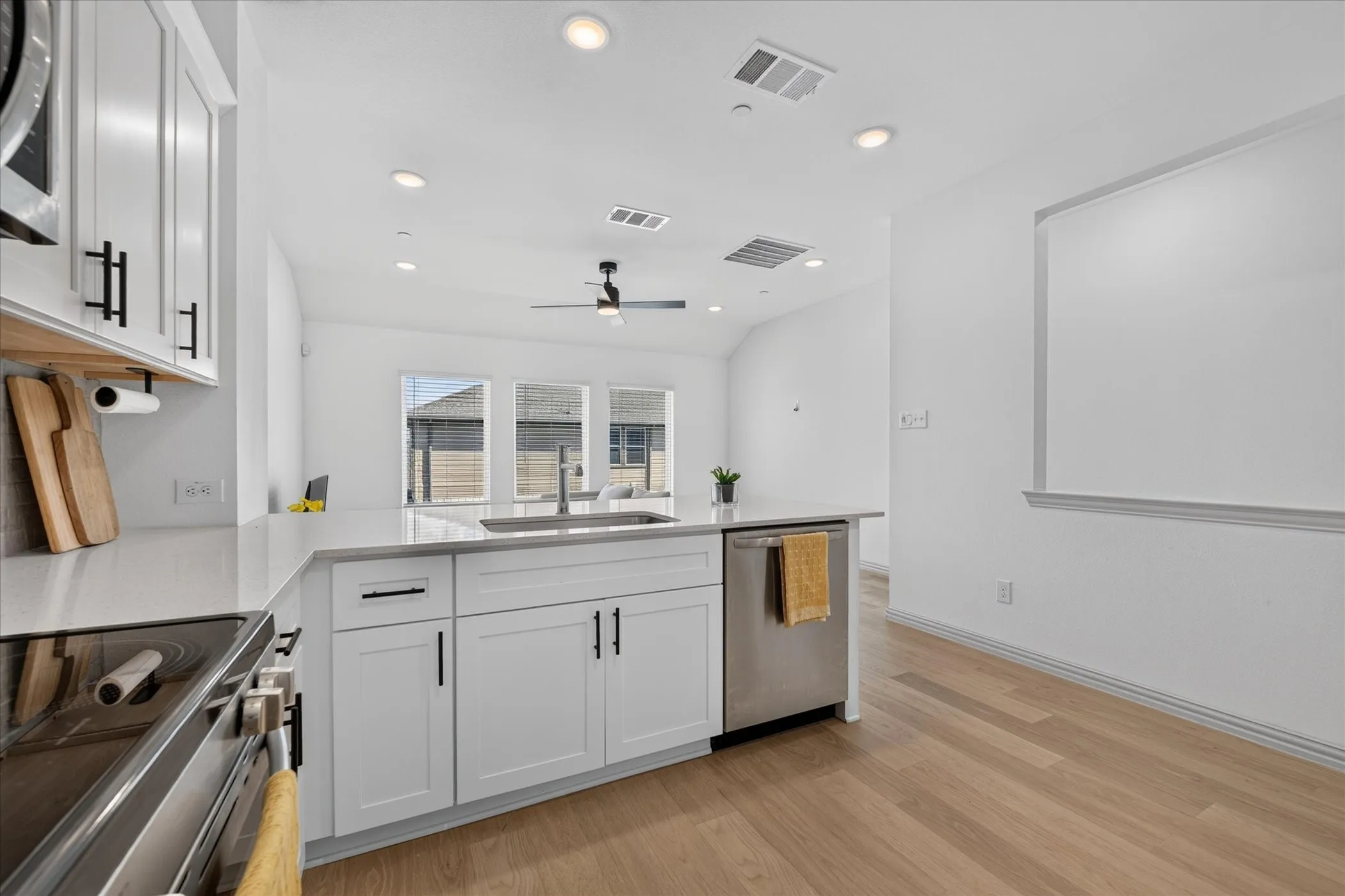 Kitchen featuring white cabinetry, light-toned countertops, an integrated sink, and stainless steel appliances