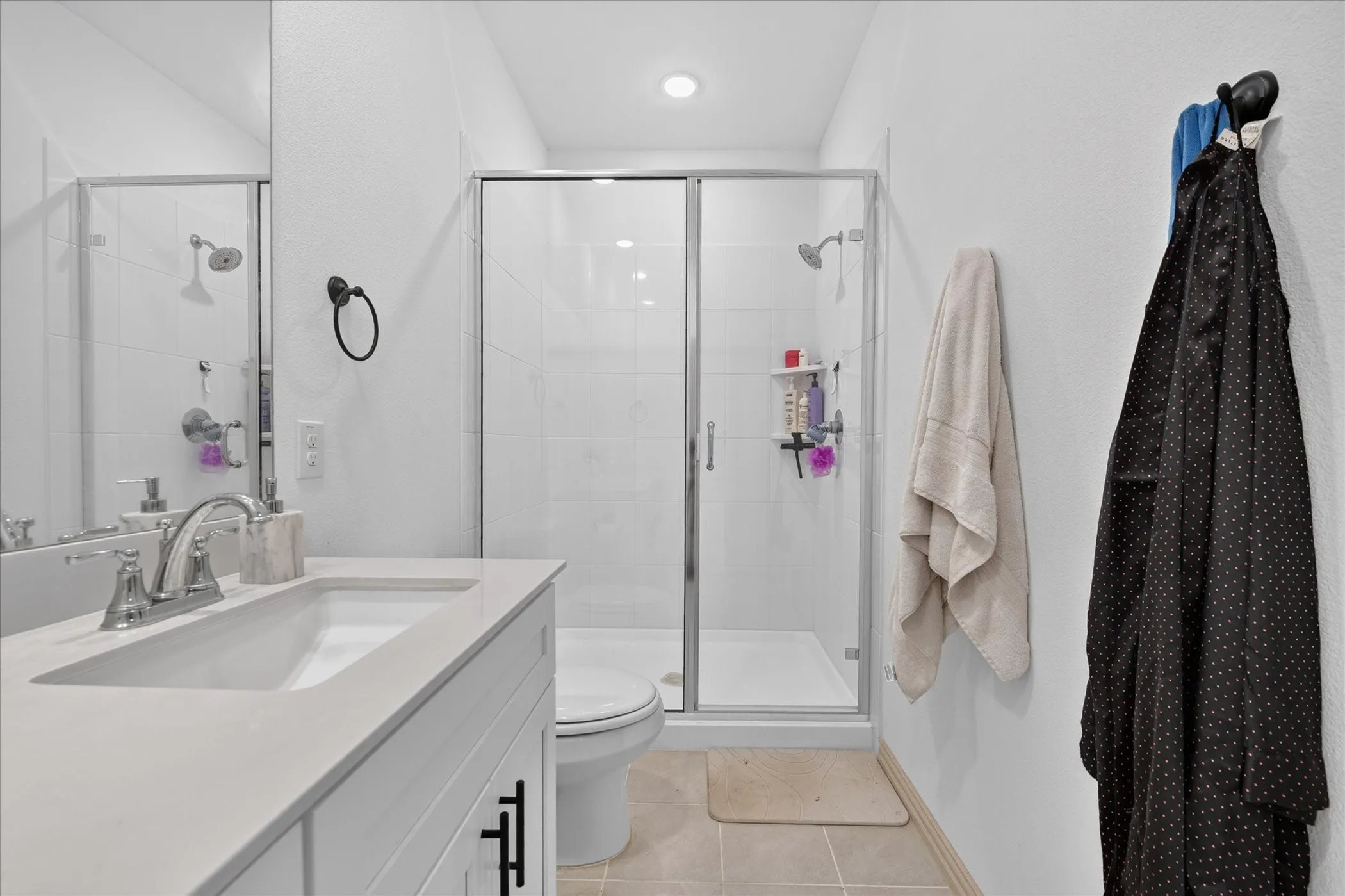 White vanity with an integrated sink, polished chrome faucet, and quartz-finish countertop