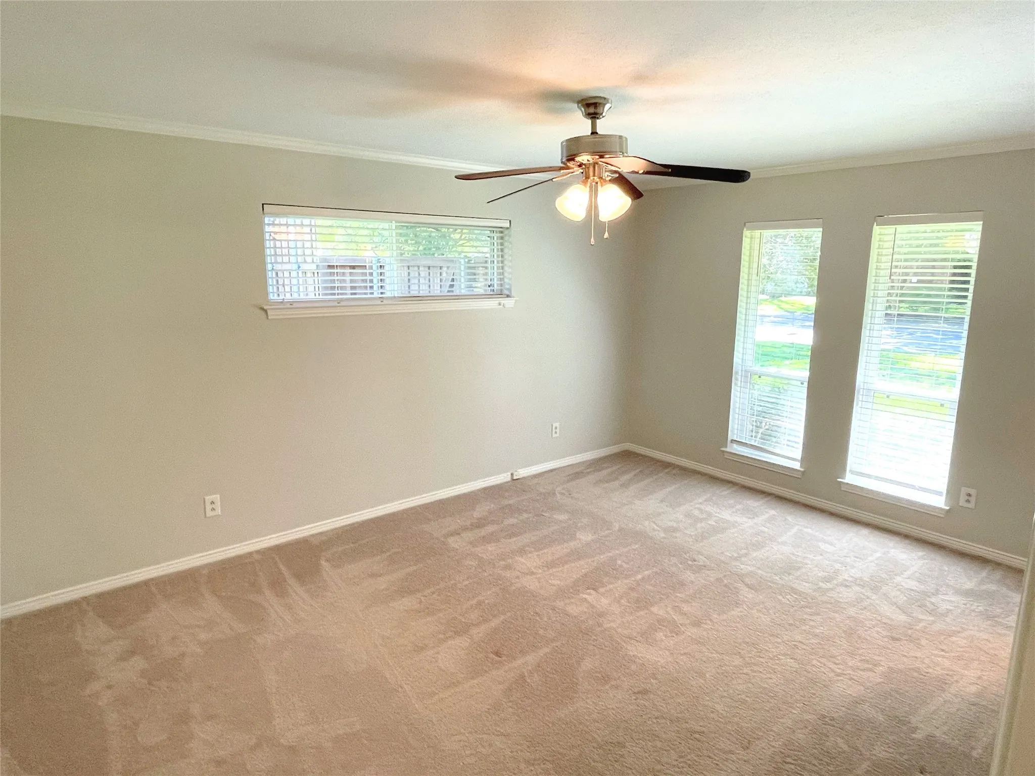 Bedroom 3 with ceiling fan, light carpet, and crown molding