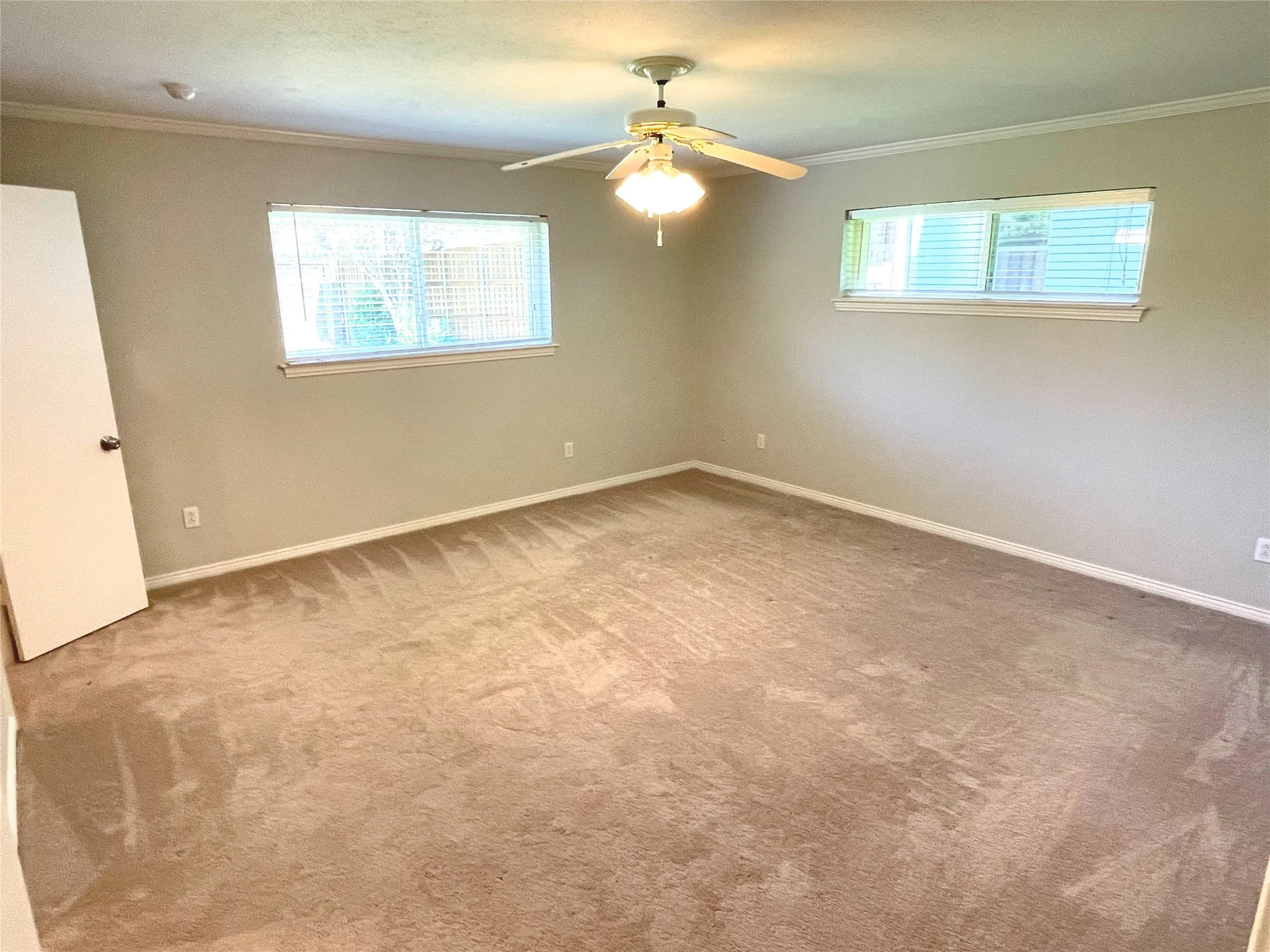 Primary bedroom with crown molding and ceiling fan