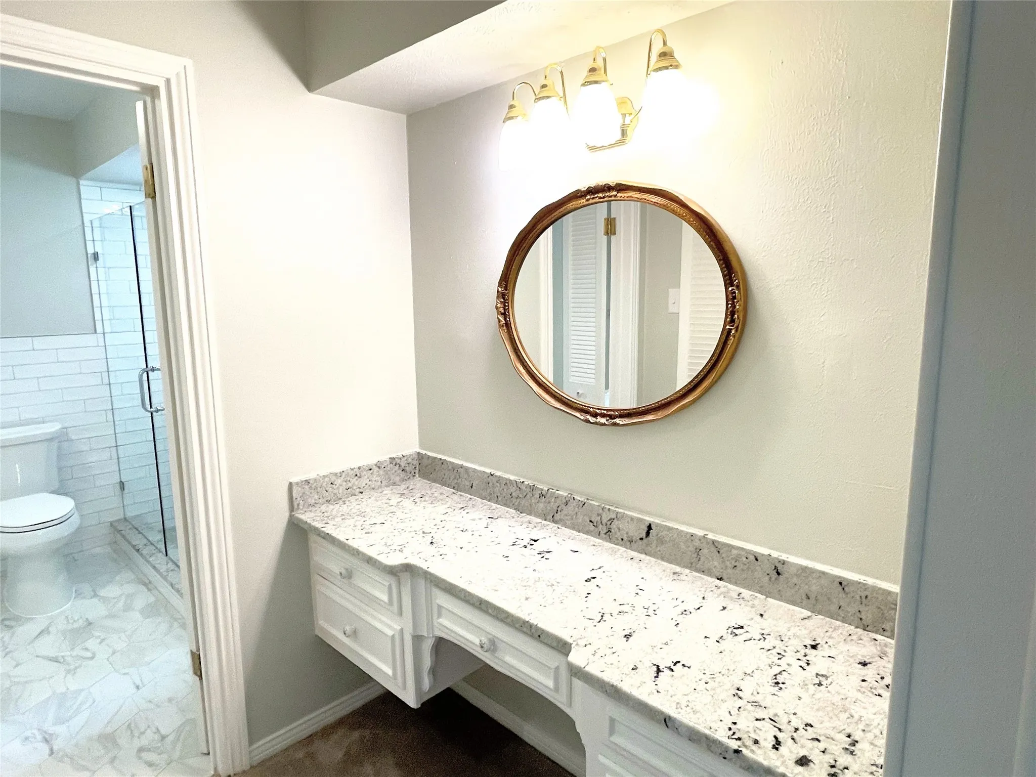Primary Ensuite Bathroom featuring walk in shower, vanity, and toilet