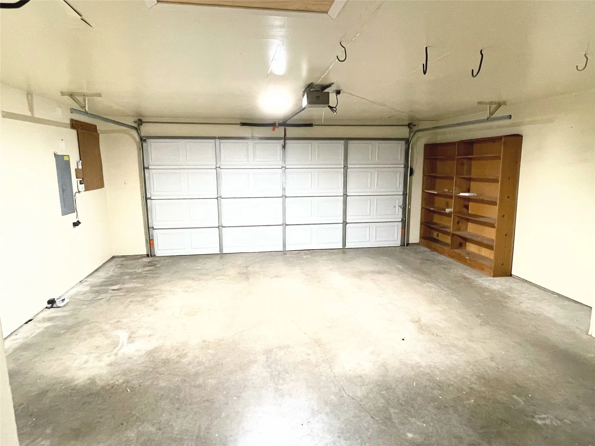 Garage with electric panel and a garage door opener