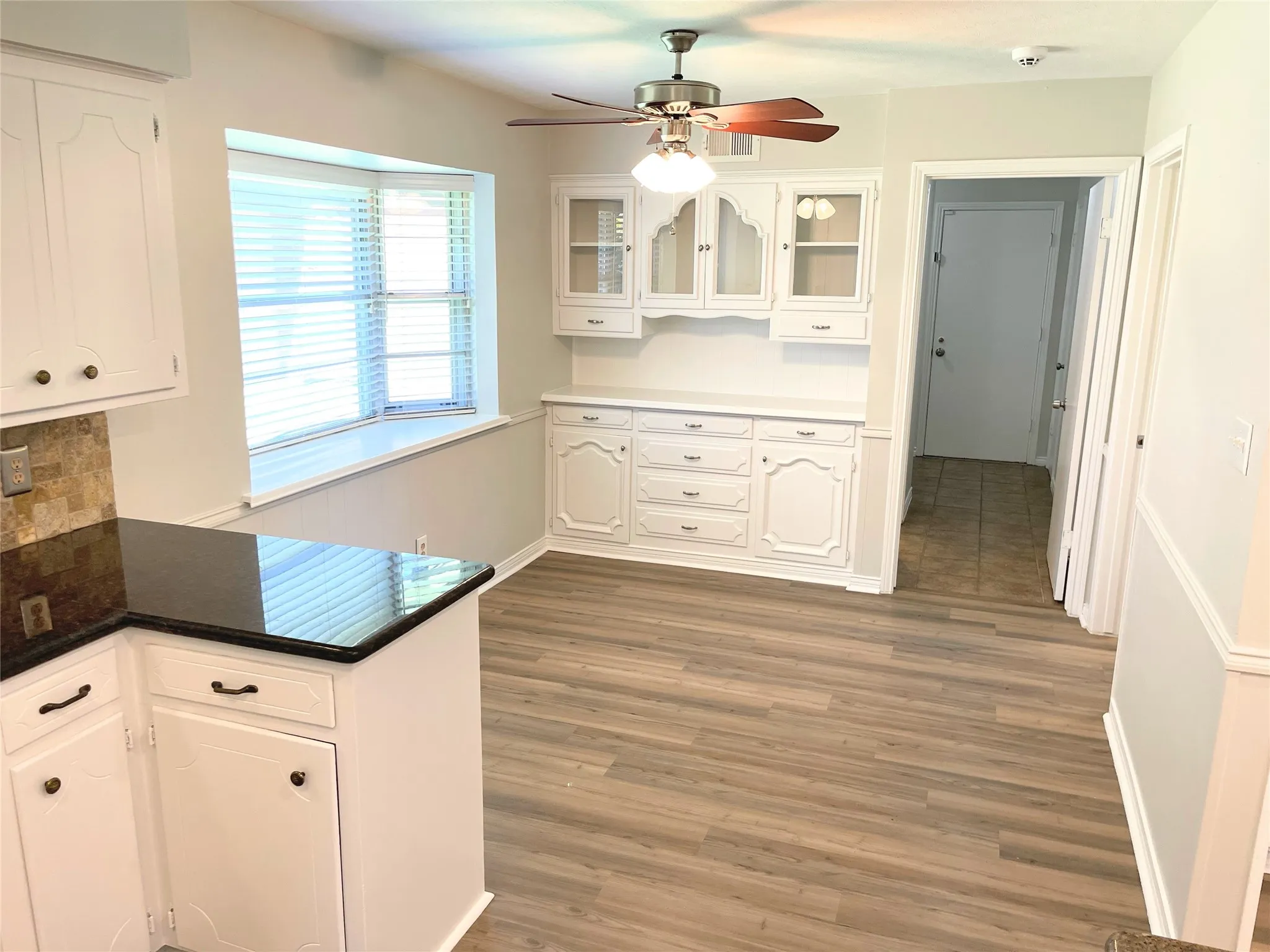 Breakfast nook with, ceiling fan, and white cabinets