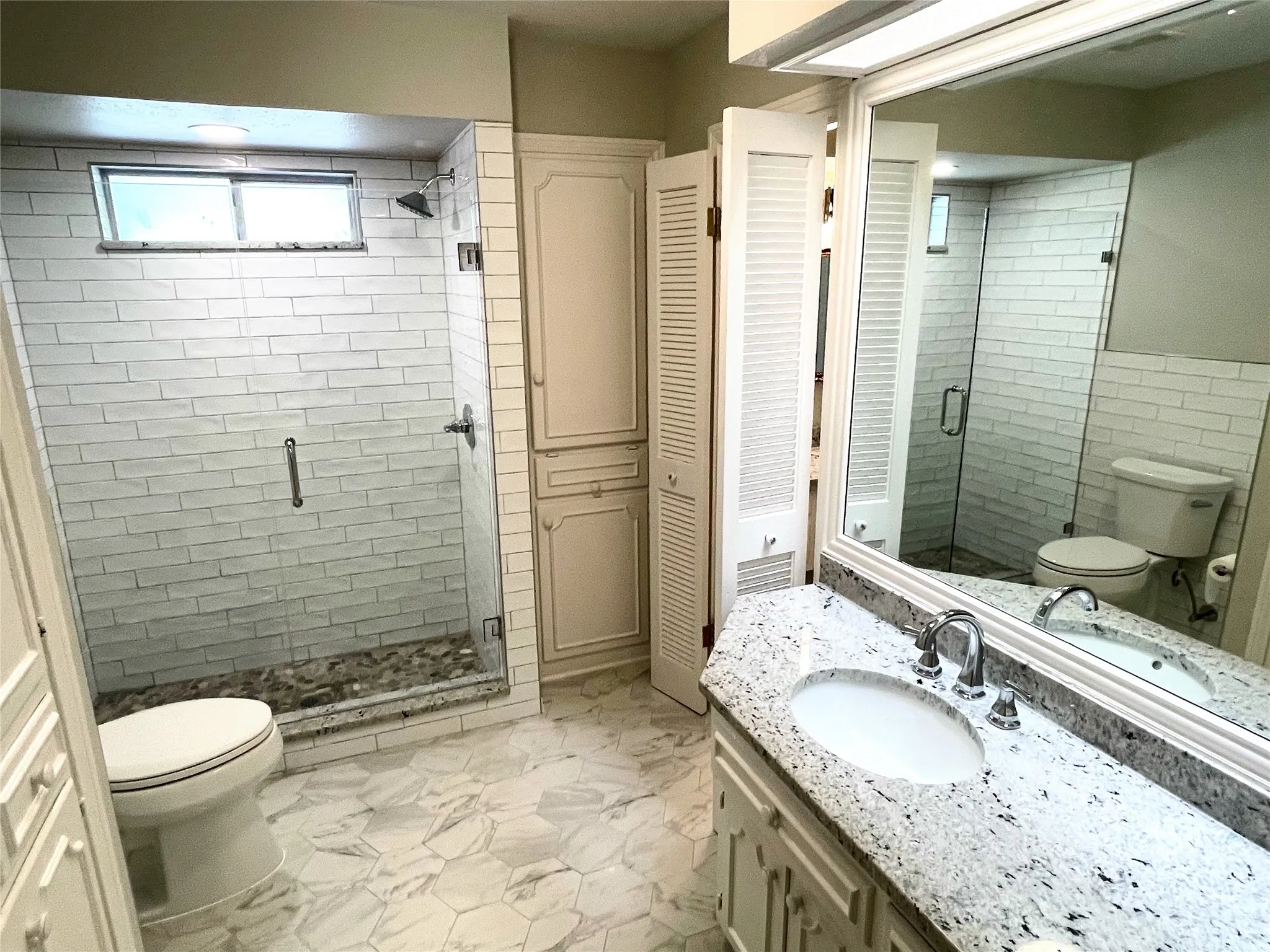 Primary Ensuite Bathroom with vanity, toilet, and a shower with door