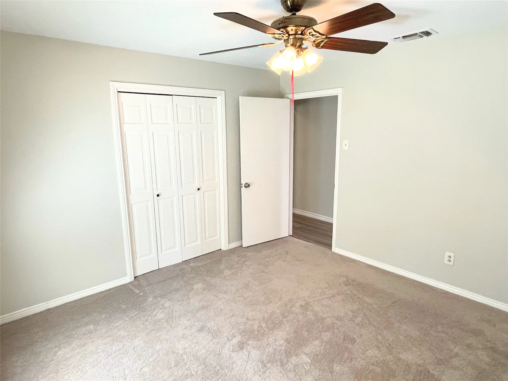 bedroom 2 featuring ceiling fan, light colored carpet, and a closet