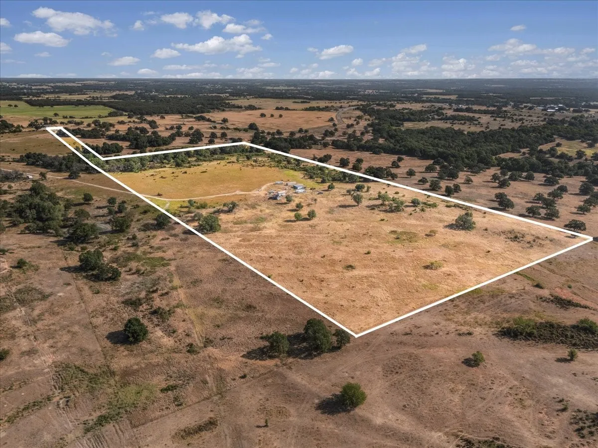 39.493 acres of expansive acreage featuring a mix of open fields and scattered mature trees