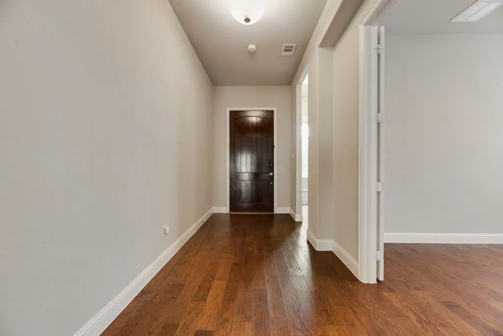 Rich wood-finish flooring extending through the entry and into interior spaces
