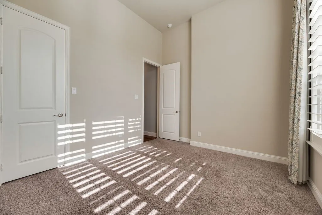 Neutral wall tones with vaulted ceilings, textured carpeting, and white trim