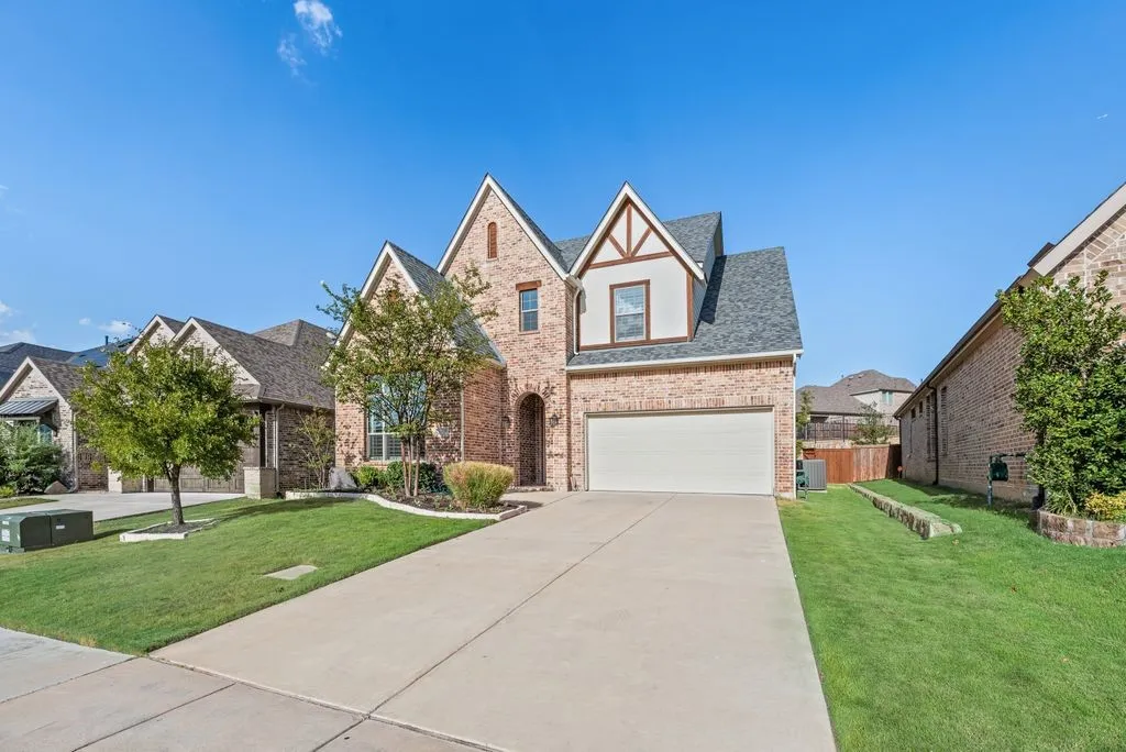 Brick facade featuring architectural gables and a two-car garage