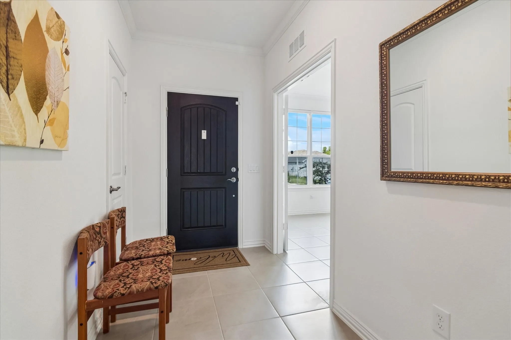 Arched entryway door with panel detailing, light tile flooring, and white interior walls