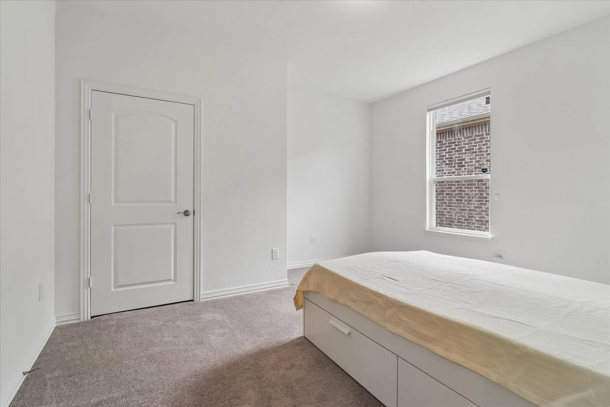 Neutral wall paint, carpet flooring, and a single window