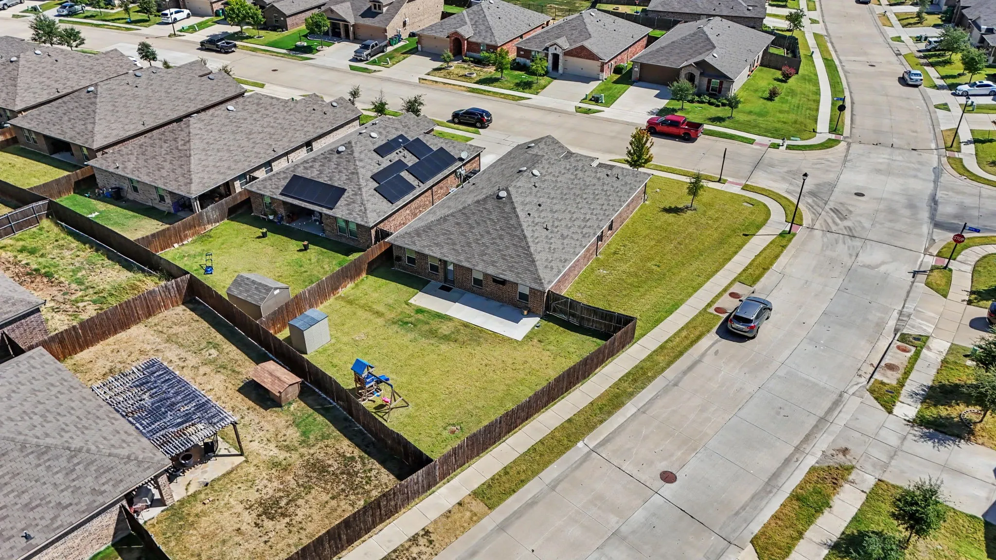 Expansive backyard featuring a manicured lawn, full privacy fencing, and a concrete patio
