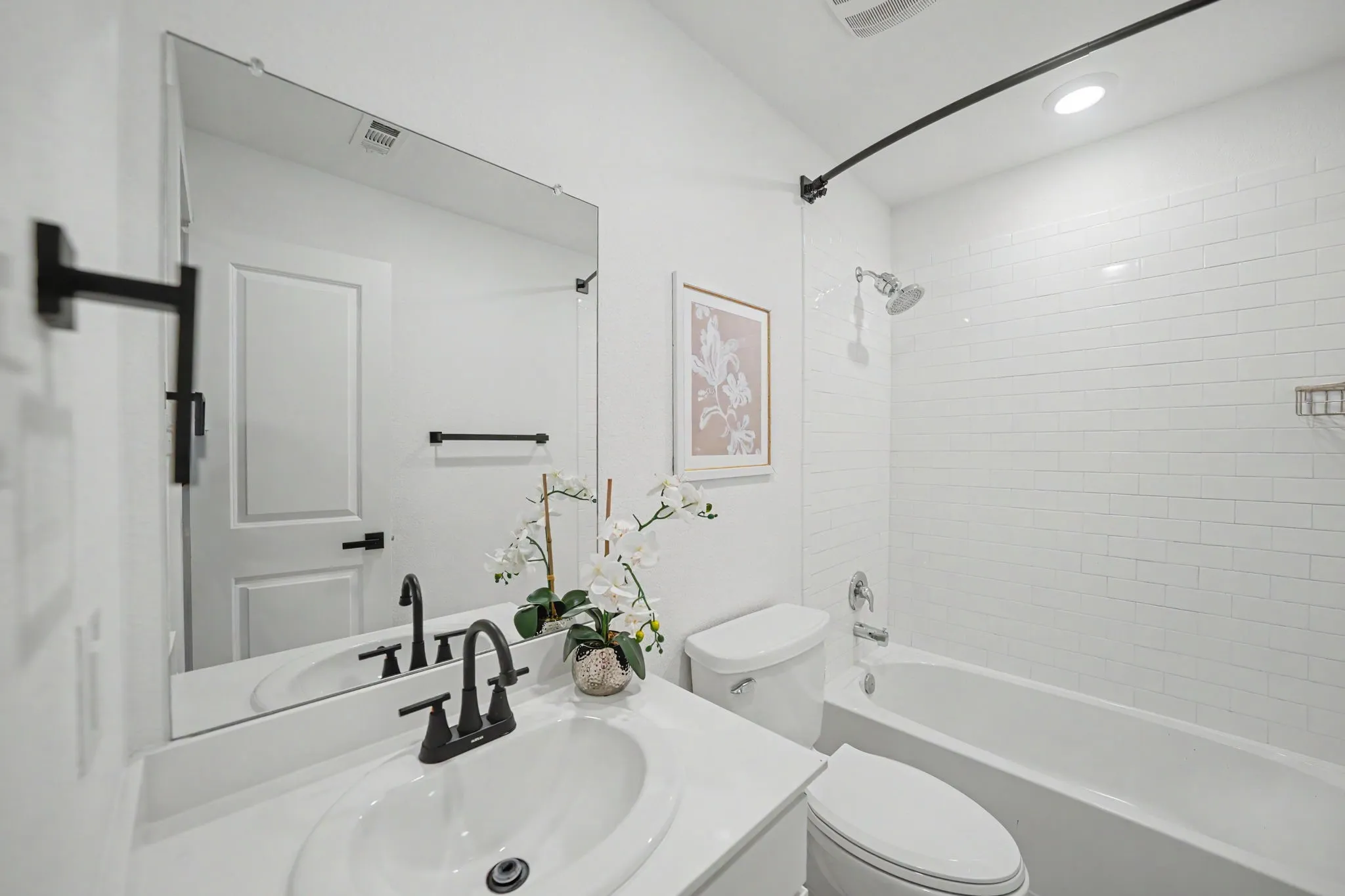 White subway tile shower surround, single vanity with integrated sink, matte black faucet, and a large wall-mounted​​‌​​​​‌​​‌‌​‌‌​​​‌‌​‌​‌​‌​​​‌​​ mirror