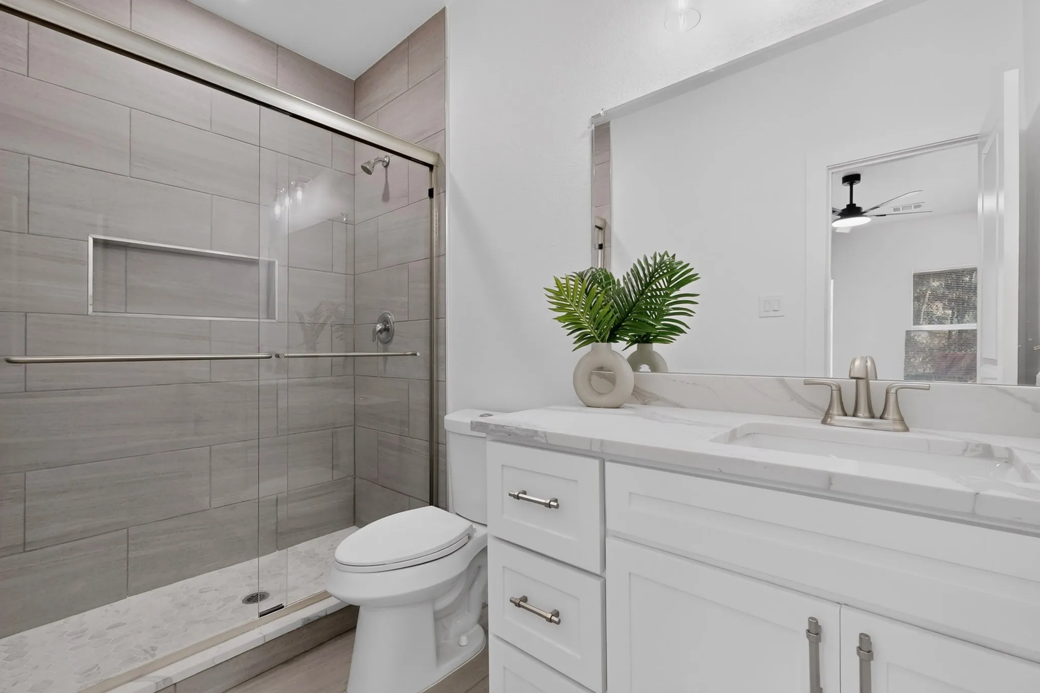 Walk-in shower with full-height tile surround and glass enclosure
