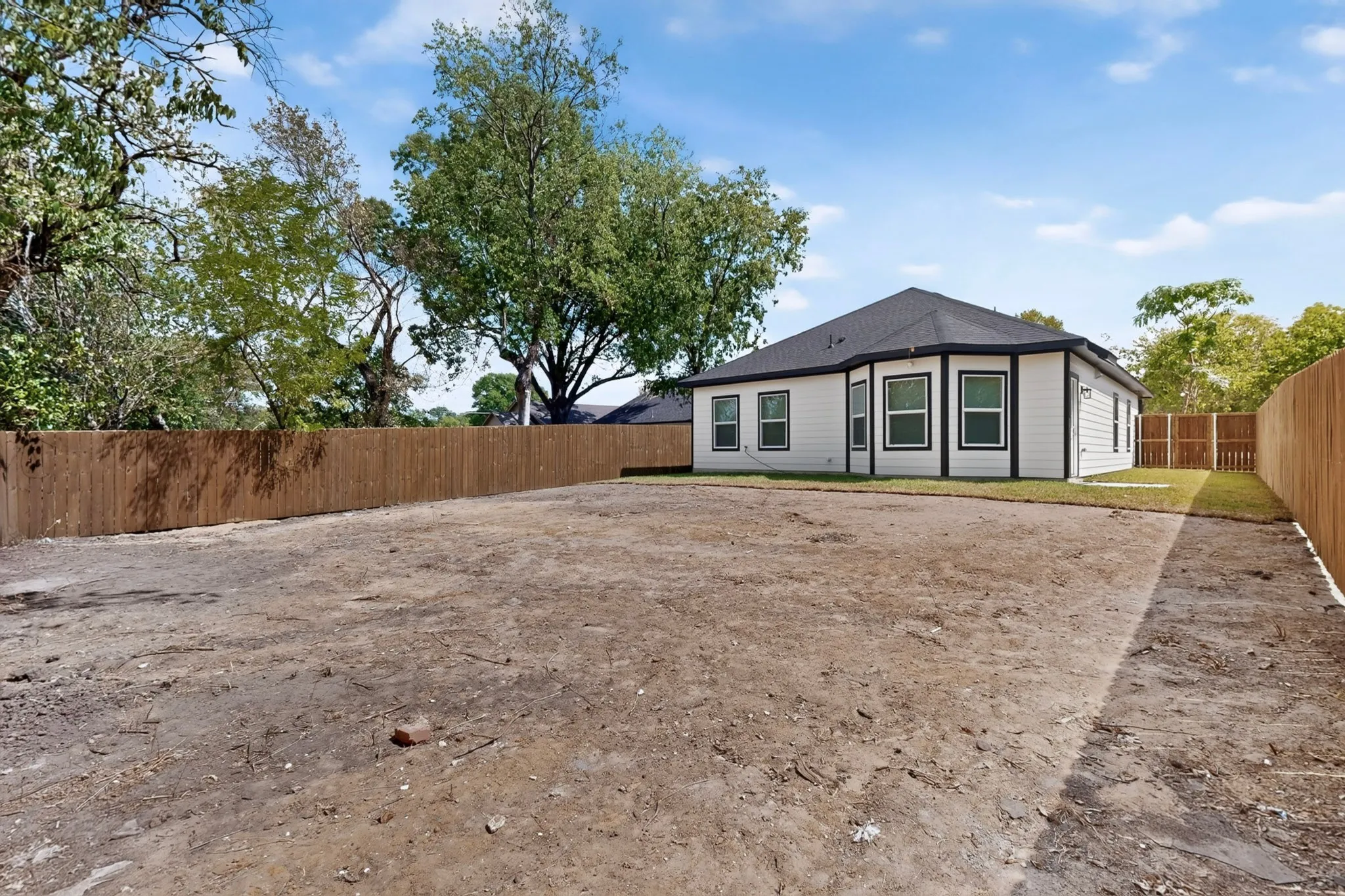 Expansive rear yard with a newly installed wood privacy fence