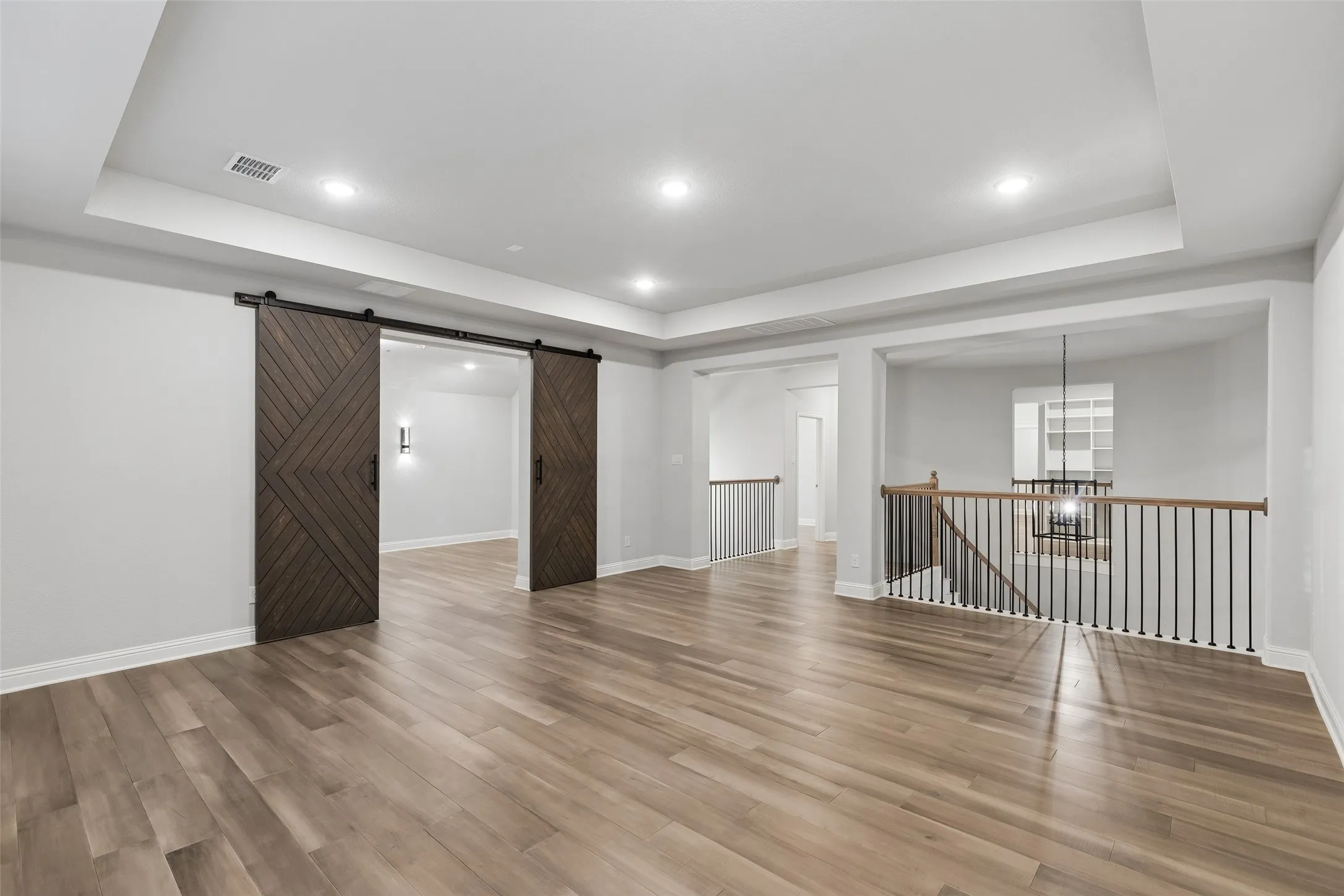 In this house, even the gameroom feels elevated with a tray ceiling and wood flooring