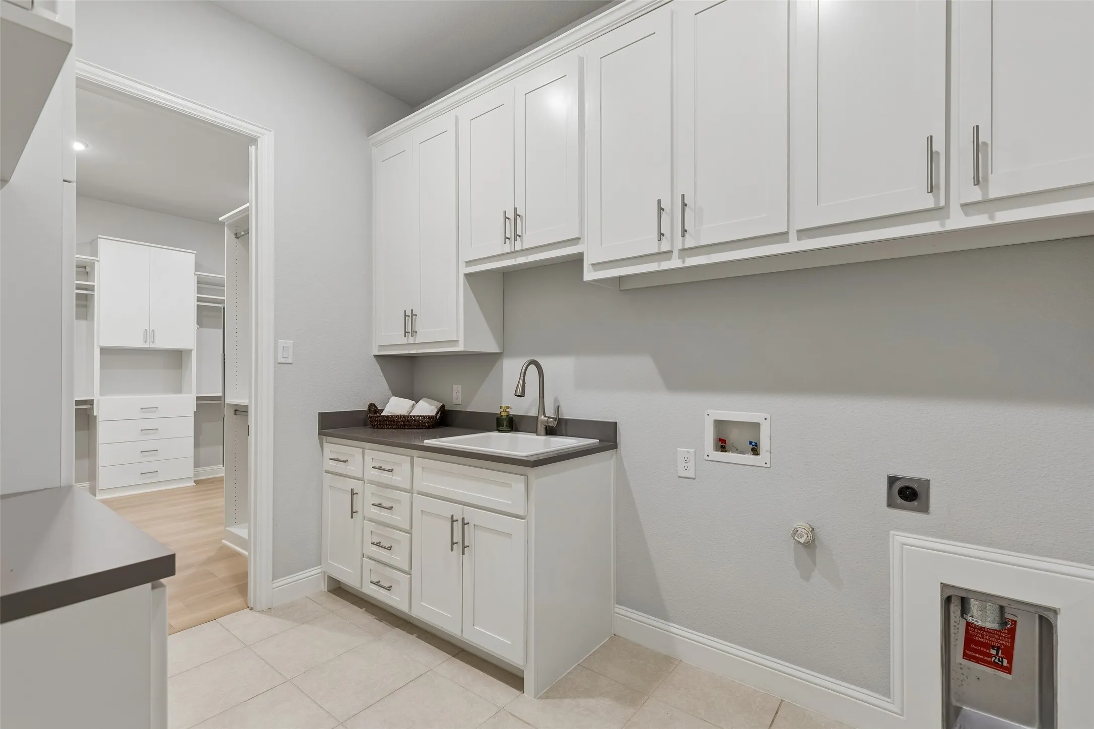 Just further into the house, is a hallway to the left with a mud room bench and hooks for gear. This is your utility room with added cabinets and counter space that also connects to the Primary Bedroom. At the end of the hallway is the door to the 2-car garage.
