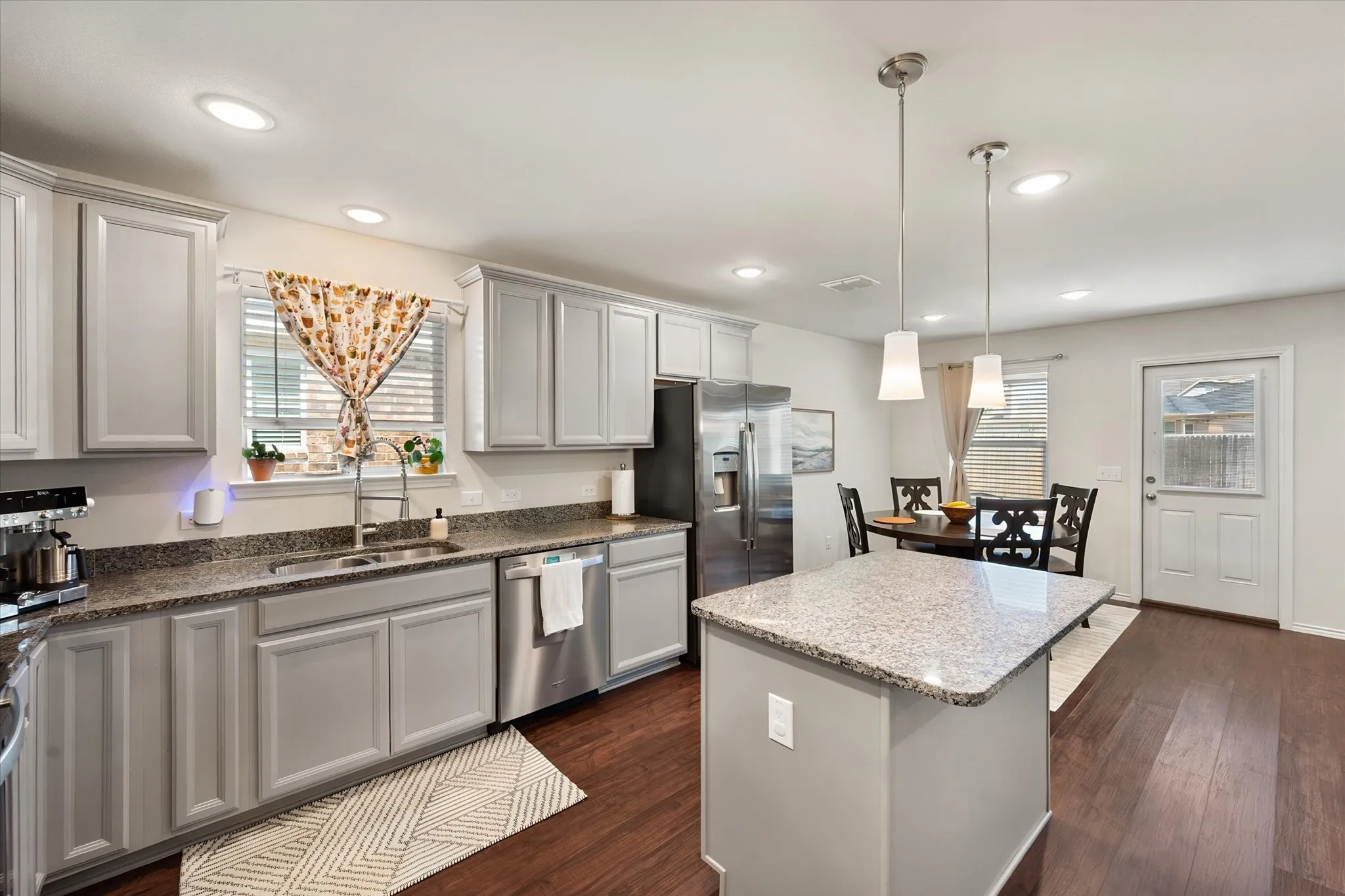Kitchen featuring dark wood-finish flooring, light-toned cabinetry, and granite countertops